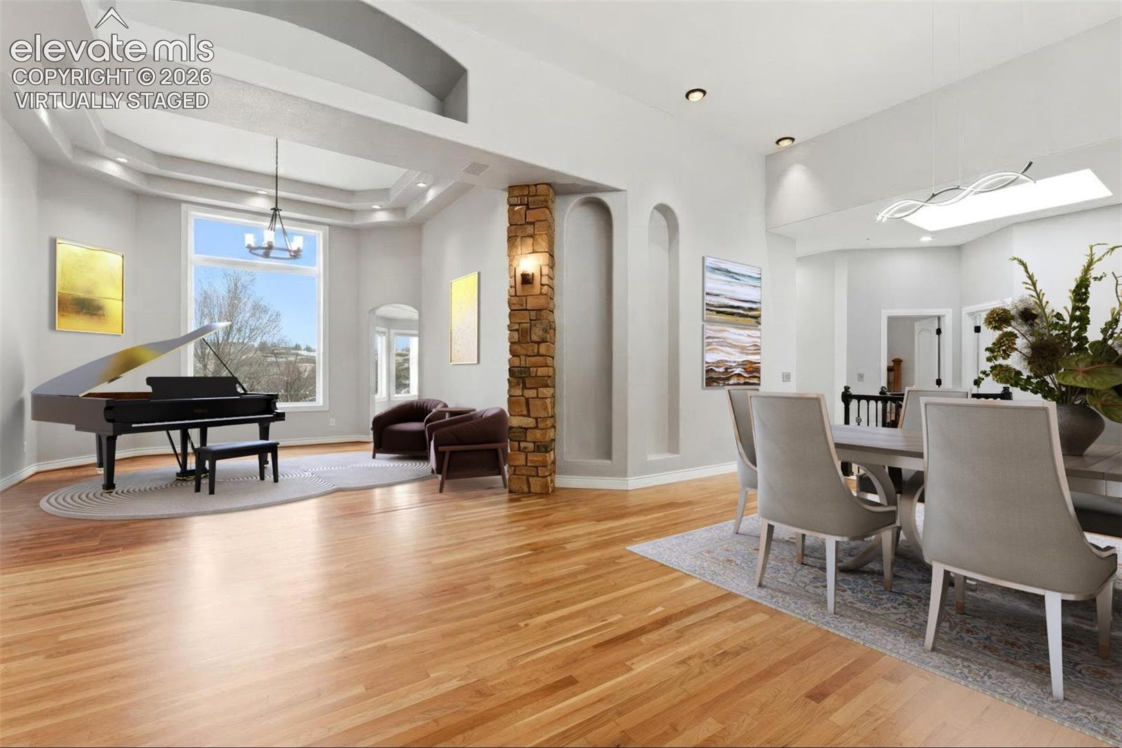 Virtually staged. Hardwood flooring throughout, tray ceiling with recessed lighting, floor-to-ceiling window, arched wall niches, and a stacked stone accent column