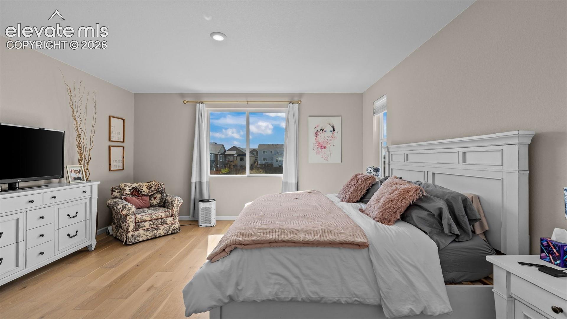 Wood-finish flooring with neutral wall tones and recessed lighting