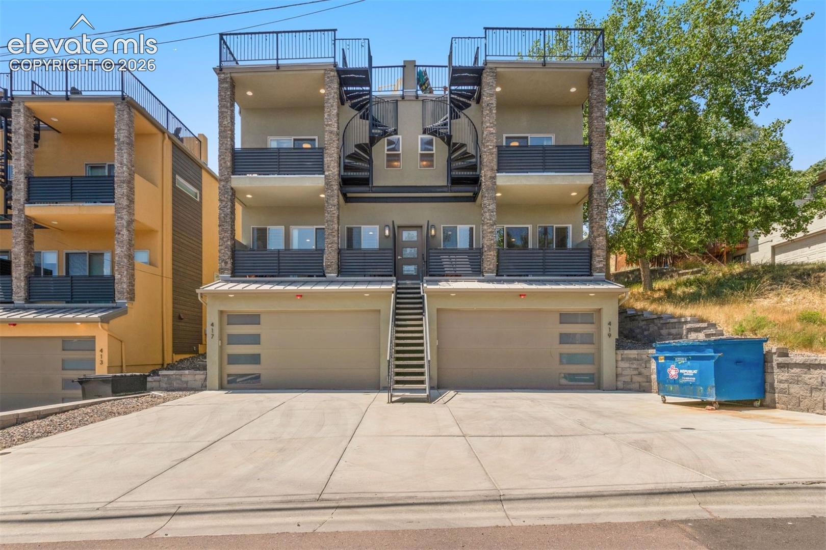 Welcome to, a stunning modern townhome built by Tara Custom Homes in 2019. Ideally located just minutes from Downtown Colorado Springs, this exceptional property offers the perfect blend of luxury, convenience, and investment potential. Previously operated as a successful income-producing property, this residence presents an outstanding opportunity for an owner-occupant, investor, or buyer seeking a turnkey furnished home. Thoughtfully designed across multiple levels, this 4-bedroom, 4-bathroom home features a private lower-level suite complete with its own ensuite bathroom, walk-in closet, and direct access from the oversized 2-car garage, ideal for guests, roommates, or additional rental flexibility. The main level is designed for both everyday living and entertaining, featuring an open-concept kitchen, dining area, spacious living room, and convenient powder room. Enjoy seamless indoor-outdoor living with both a welcoming front deck and a private rear patio. Upstairs, you’ll find three additional bedrooms, including a private primary retreat with a walk-in closet and luxurious ensuite bathroom. Step directly from the primary suite onto your own private deck, where a spiral staircase leads to the show-stopping rooftop terrace. The expansive rooftop deck is truly a standout feature, complete with an outdoor linear gas fire pit and breathtaking 360-degree views of the surrounding mountains, city lights, and iconic Colorado scenery. With four separate outdoor living spaces, this home offers an incredible opportunity to enjoy Colorado’s outdoor lifestyle year-round. Offered fully furnished and professionally designed, is completely move-in ready and perfectly positioned as a turnkey residence, vacation home. An additional opportunity exists to purchase the neighboring property. Allowing buyers to acquire both homes as a rare, paired package.