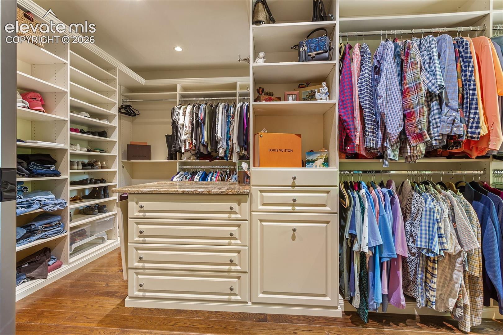 Beautiful walk in closet with a washer and dryer for upper primary bedroom