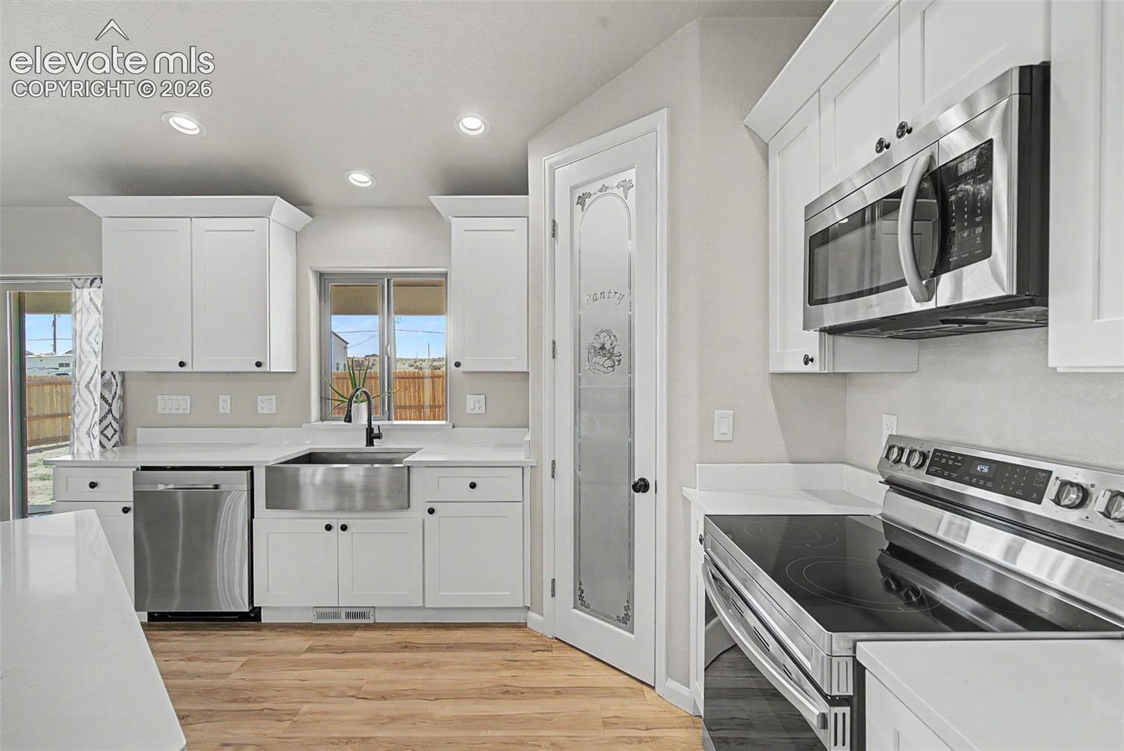 Modern kitchen featuring white shaker cabinetry and stainless steel appliances