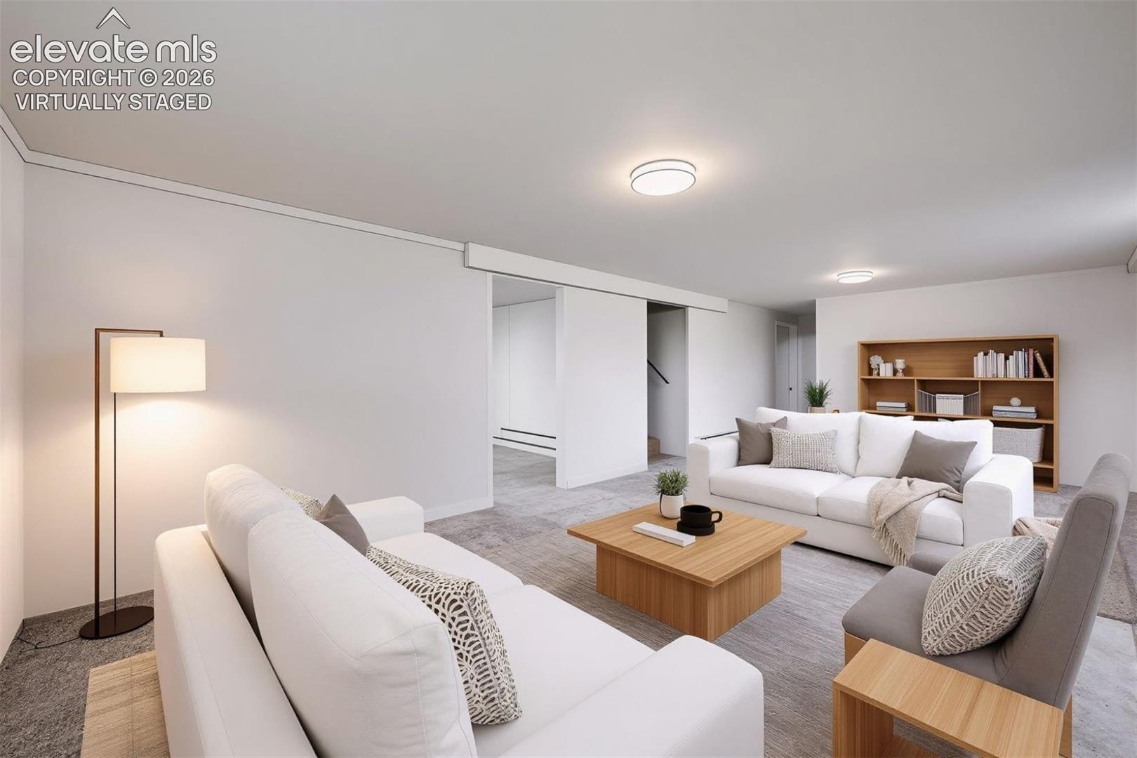Expansive living area with recessed lighting, light-toned walls, and wood-finish flooring. Virtually staged.