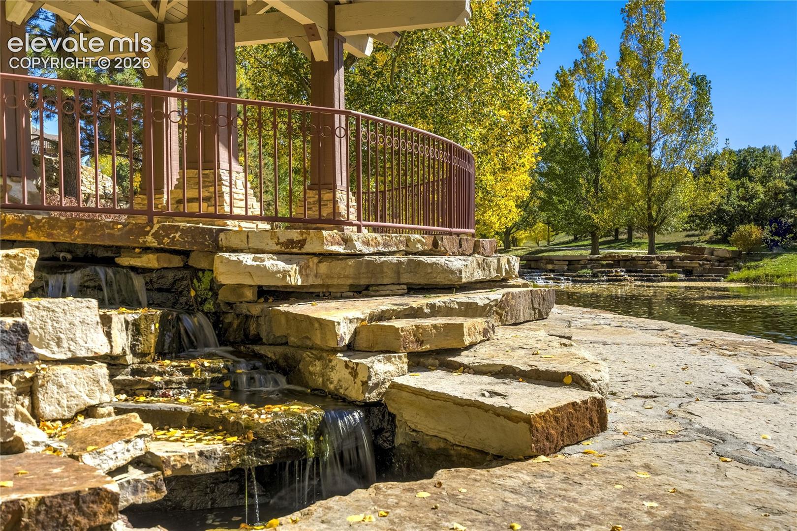 A charming pedestrian bridge crosses the community's cascading water feature, where thoughtfully designed stonework + mature landscaping create an inviting place to explore the neighborhood's scenic surroundings.