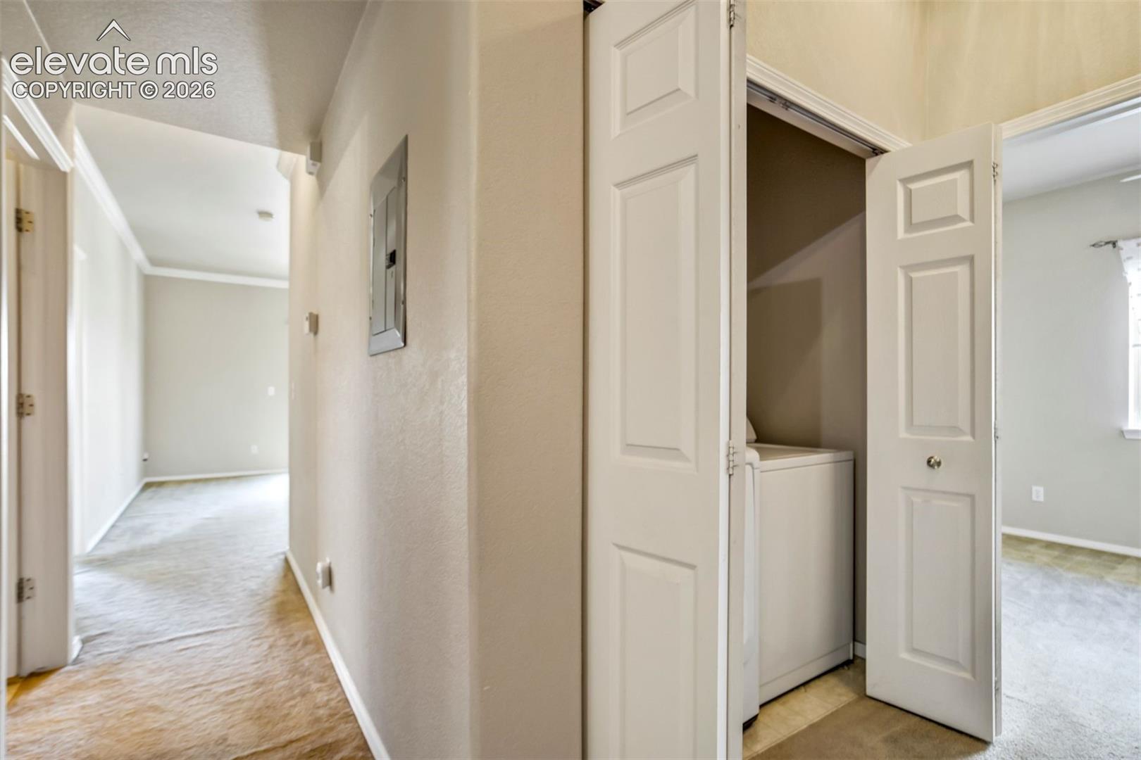 Hallway with laundry and access to bedroom