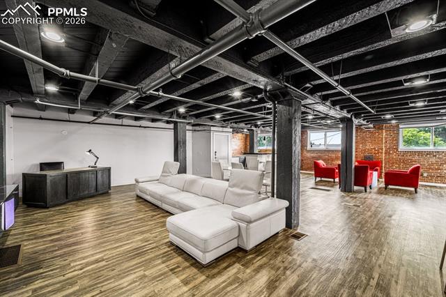 Living area featuring brick wall and wood finished floors