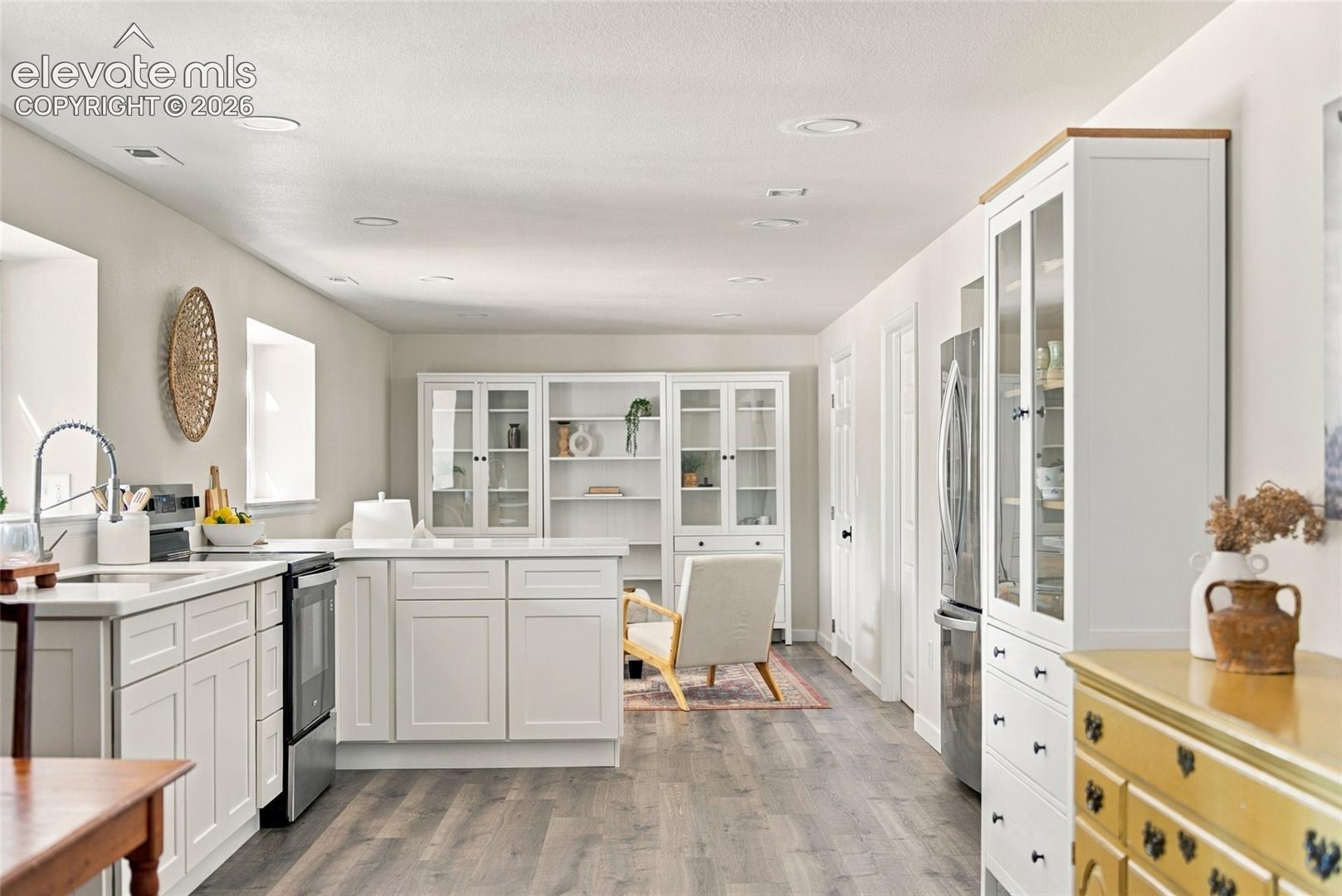 Basement White cabinetry with a center island and stainless steel appliances