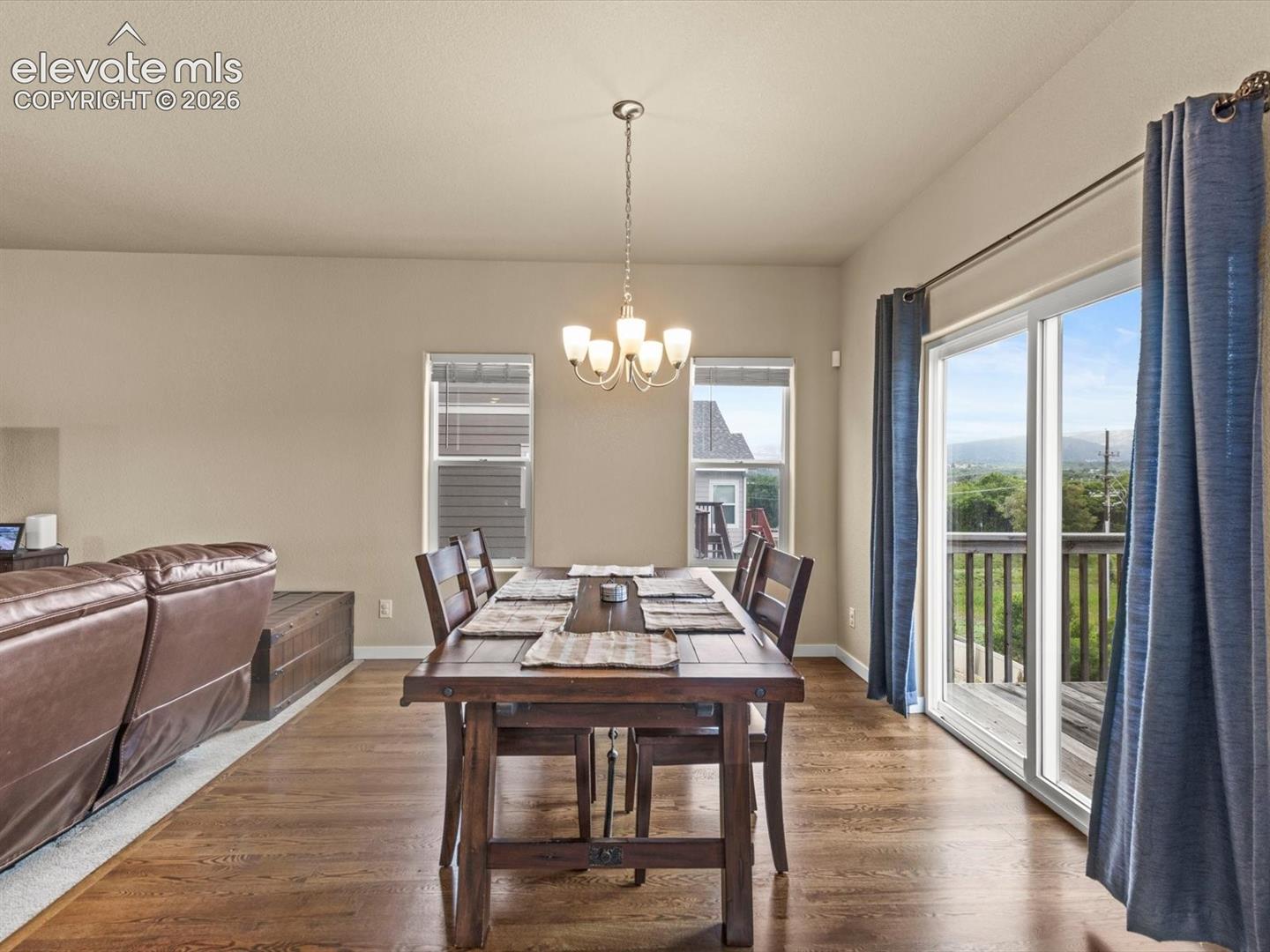 Dining area featuring wood-finish flooring and a central chandelier