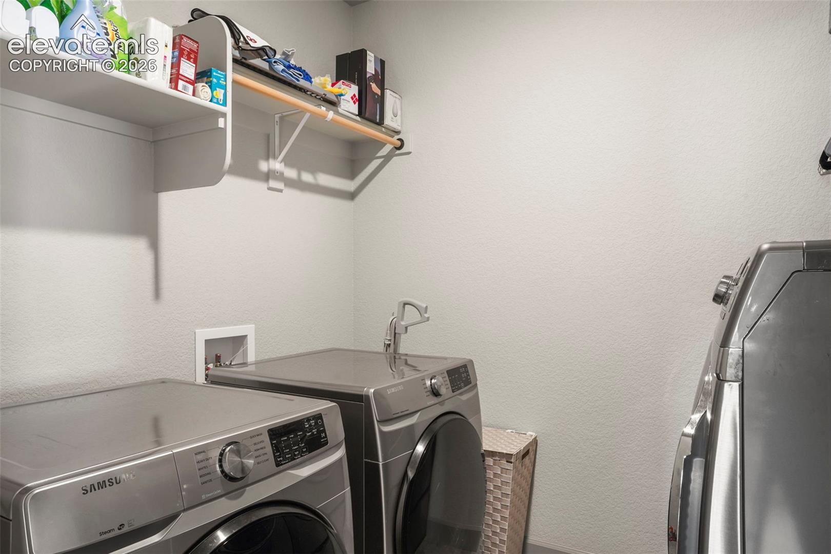 Dedicated laundry area featuring light-toned walls and built-in shelving