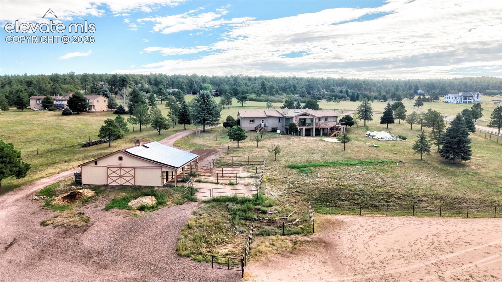 Expansive property featuring a residence, barn, and multiple fenced areas