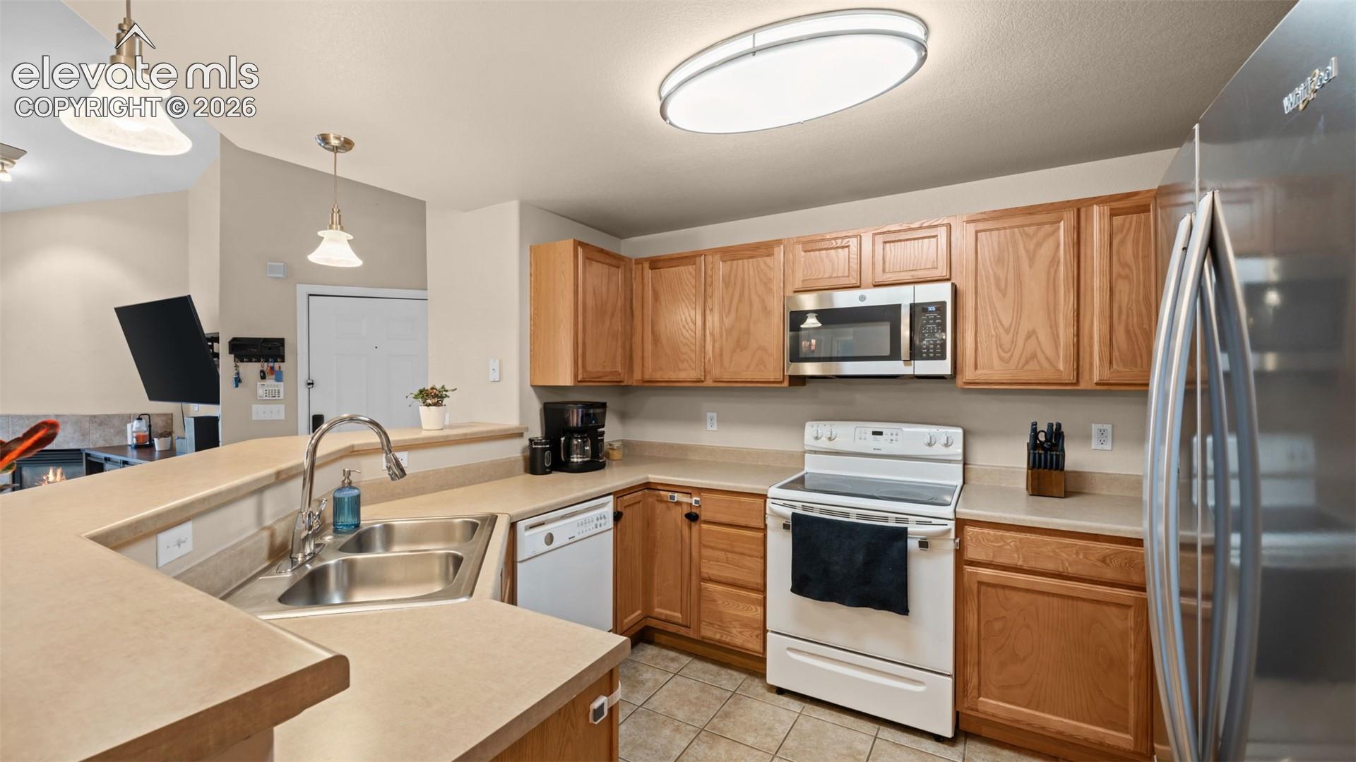 Kitchen featuring wood cabinetry, stainless steel sink, and light-colored countertops
