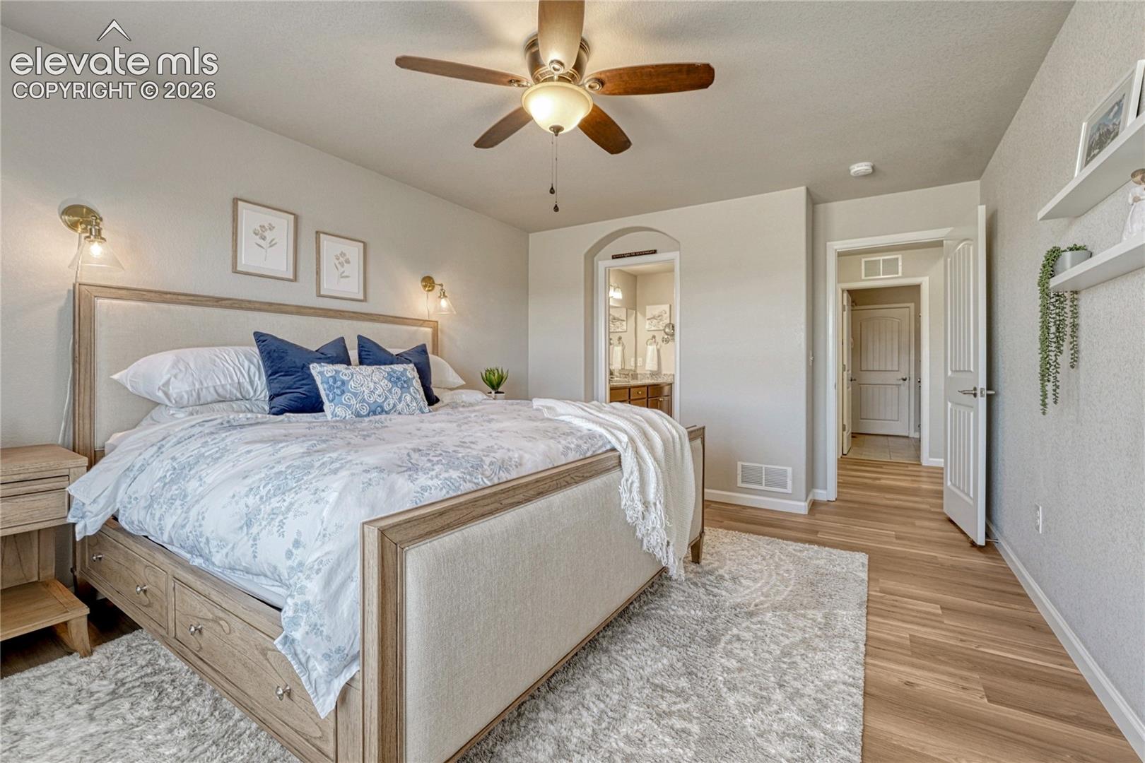 The main-level primary suite offers comfort and convenience with spacious proportions, luxury vinyl flooring, and direct access to the private bathroom.