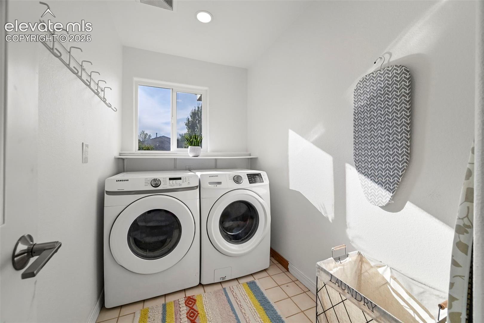 Laundry area featuring tile flooring, a built-in shelf, and a window