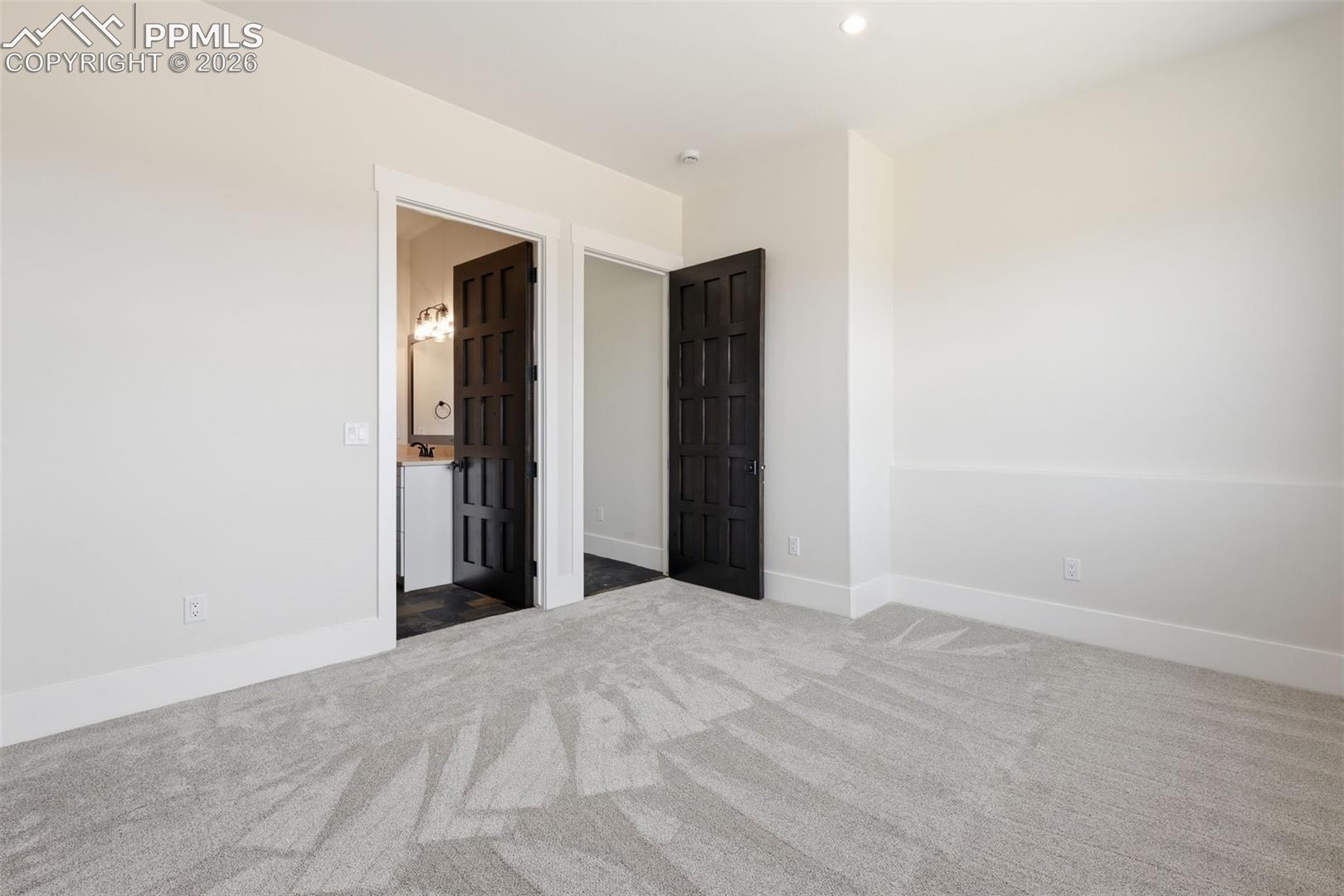 3rd bedroom on lower level looking into 3-piece bath and entrance hallway.