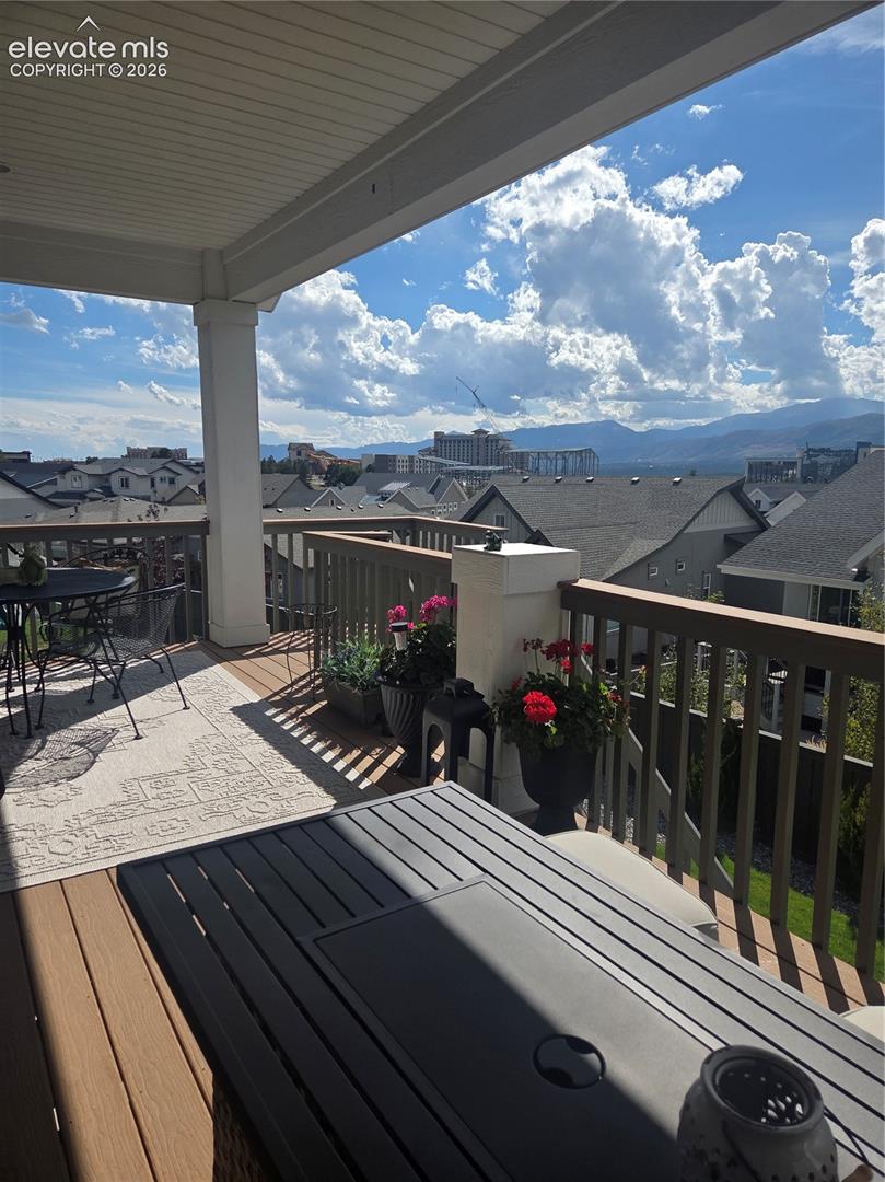 Covered outdoor deck with composite decking, white ceiling, and wooden railings