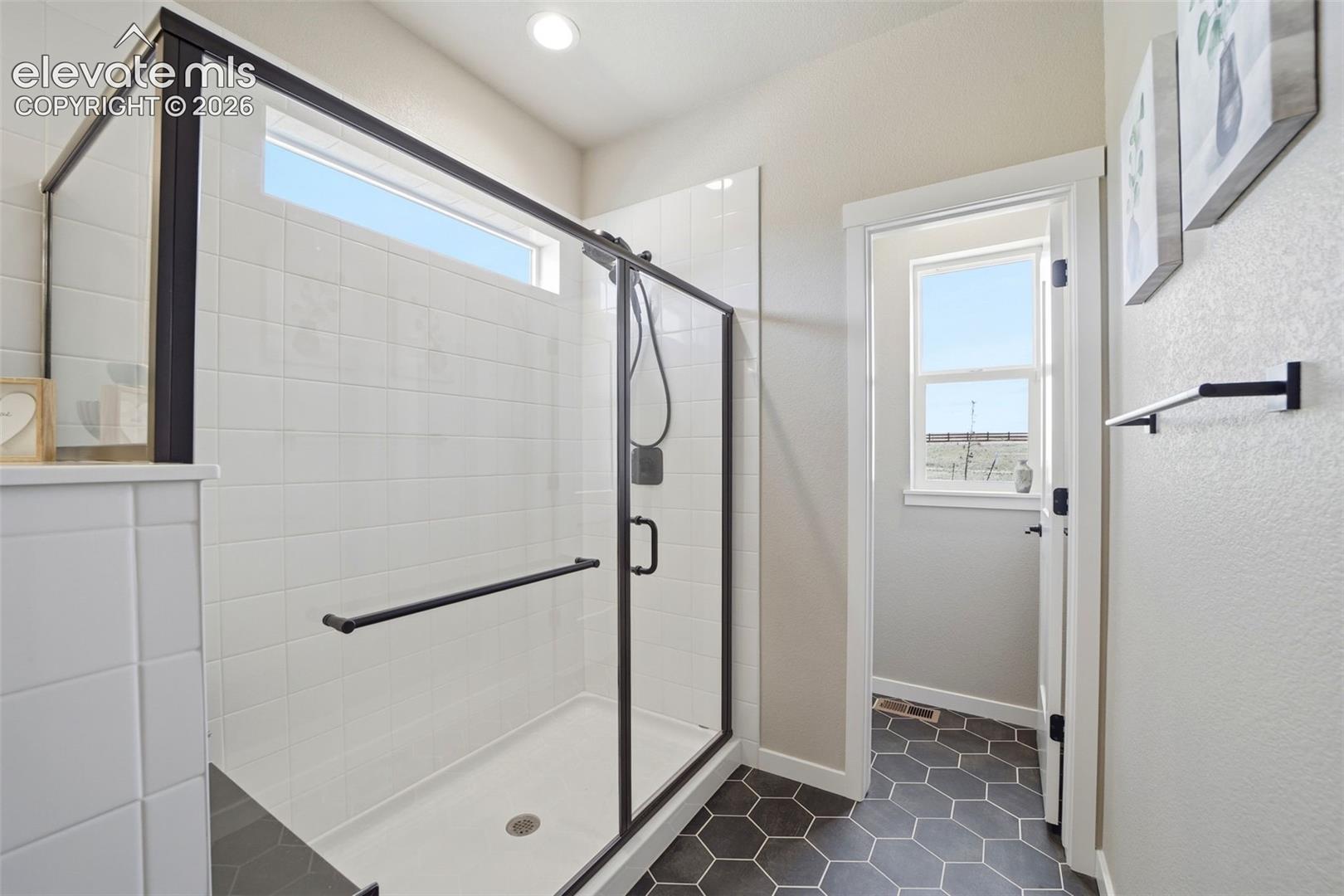 Extended shower with a bench, and a private water closet (with a window). 