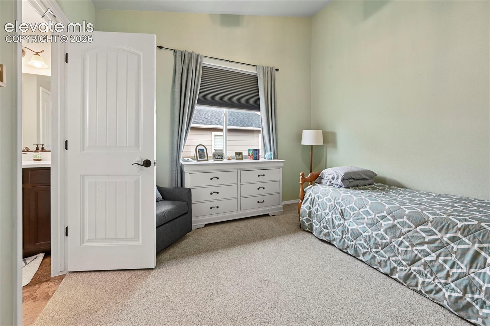 Room featuring neutral carpeting and a two-panel arched interior door with matte black hardware