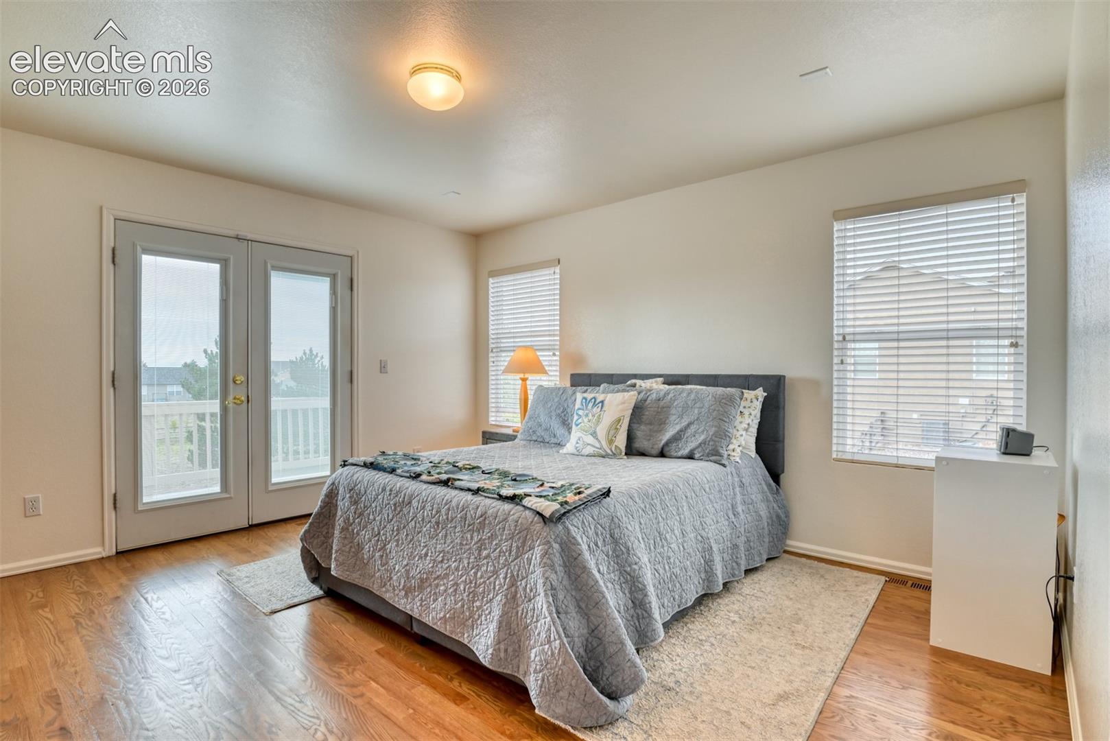 Warm hardwood flooring with a ceiling-mounted light fixture