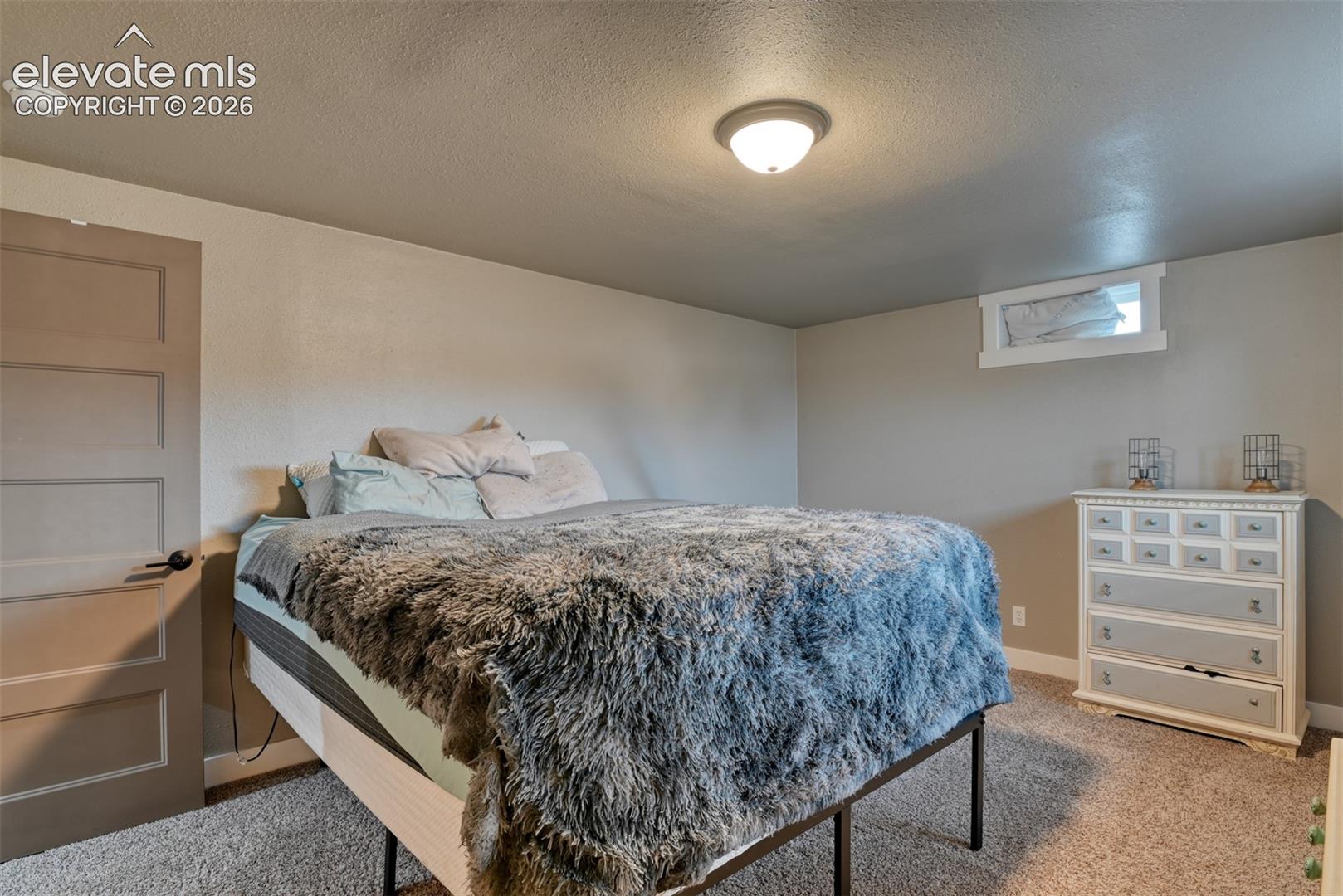 Bedroom featuring light carpet and a textured ceiling