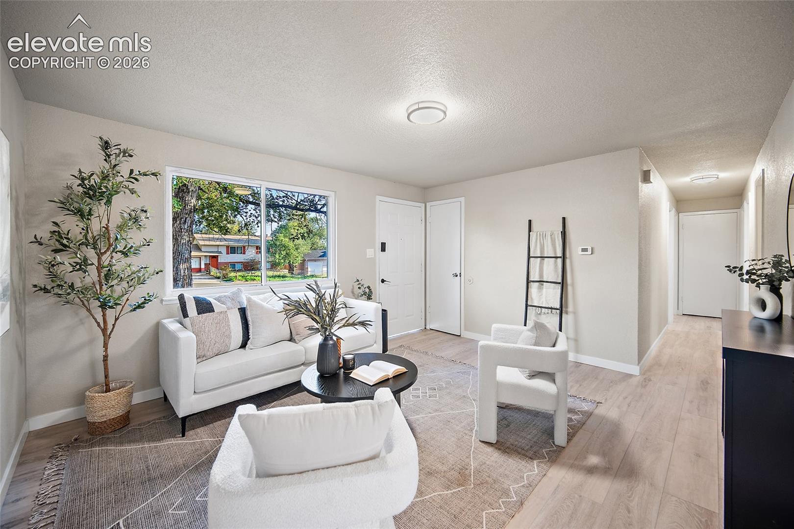 Light-toned wood-finish flooring, white walls, and recessed lighting create a bright interior