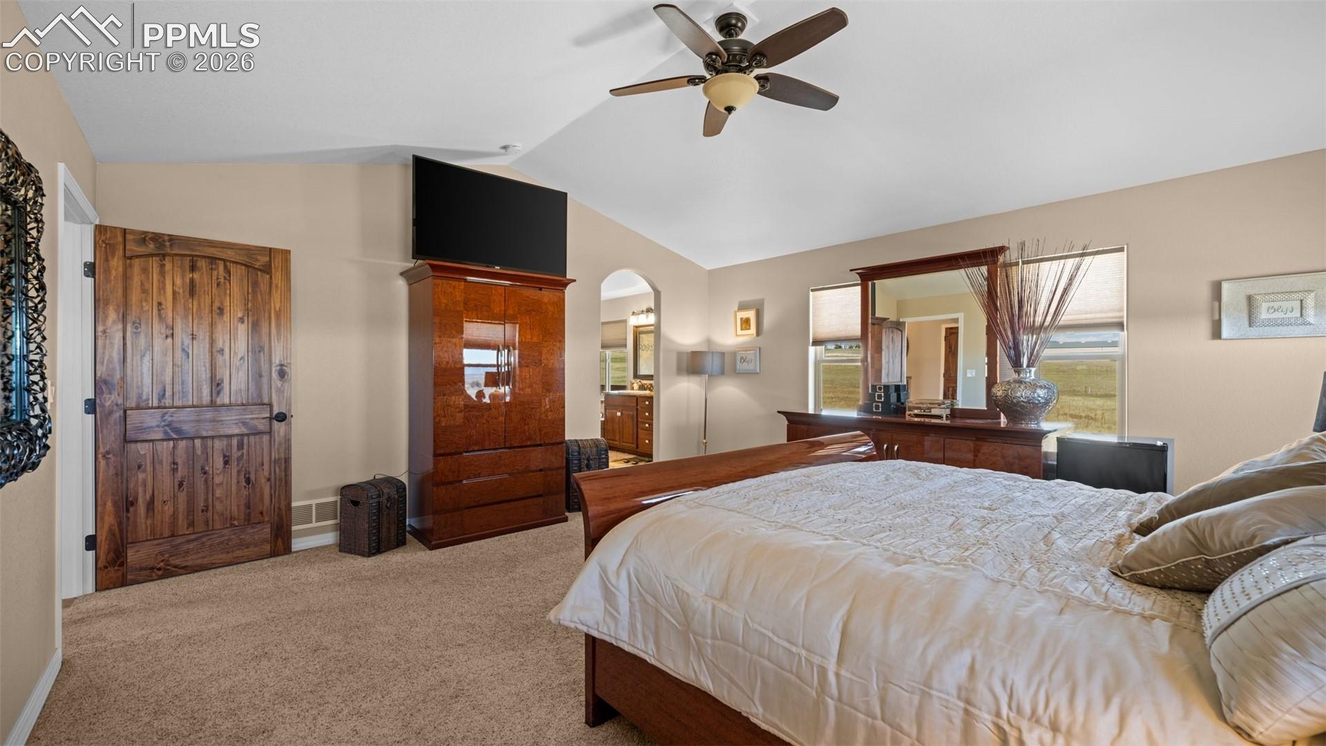 Primary bedroom, arched walkways, ceiling fan, and ensuite bathroom