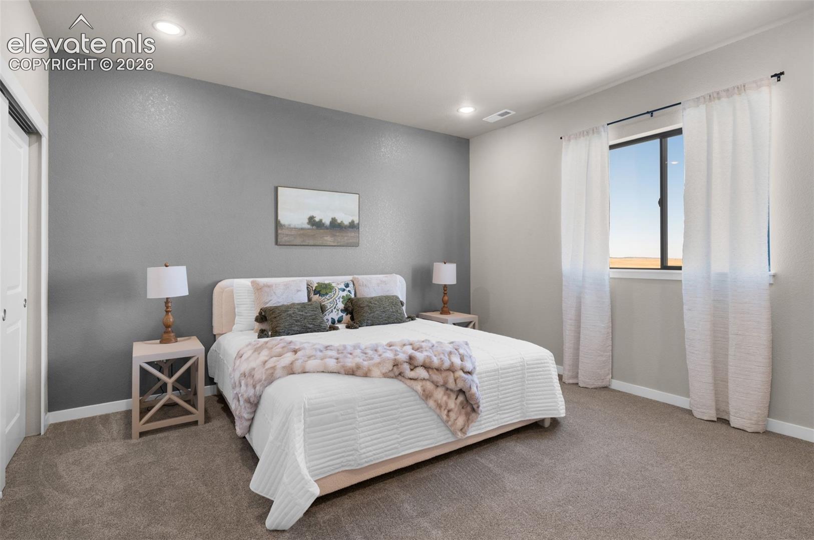 Recessed lighting, neutral gray wall, white trim, carpeted flooring, and a single window