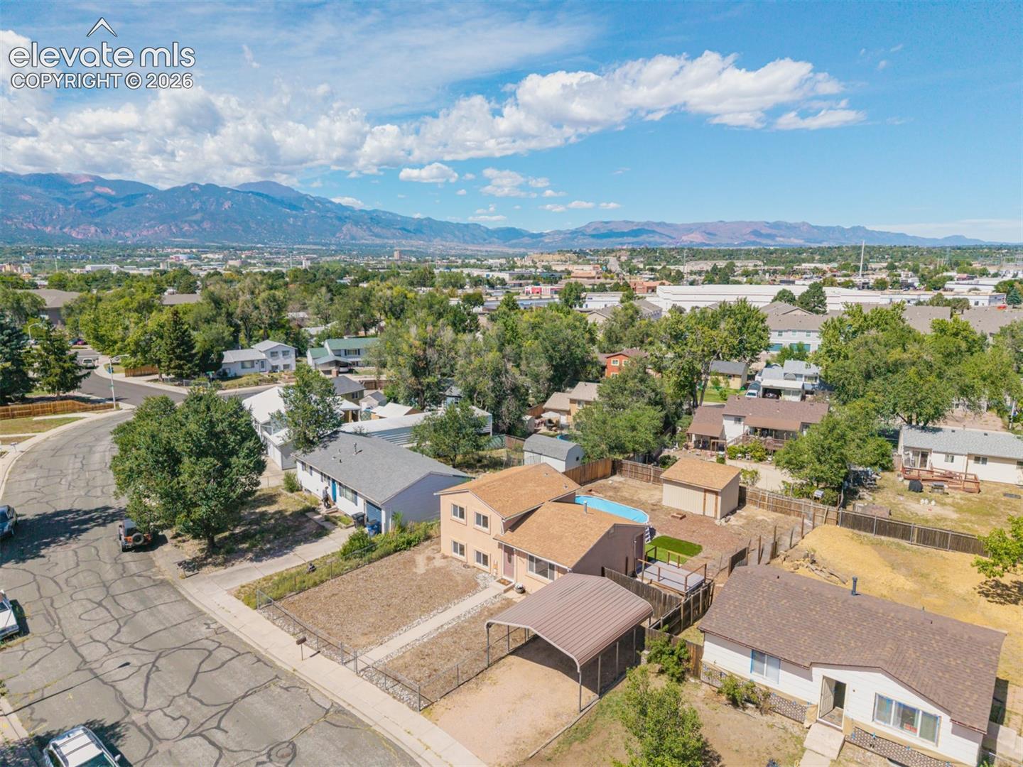 Spacious lot featuring a detached carport, fenced yard, and an above-ground pool on a quiet street conveniently located near Ft. Carson. 