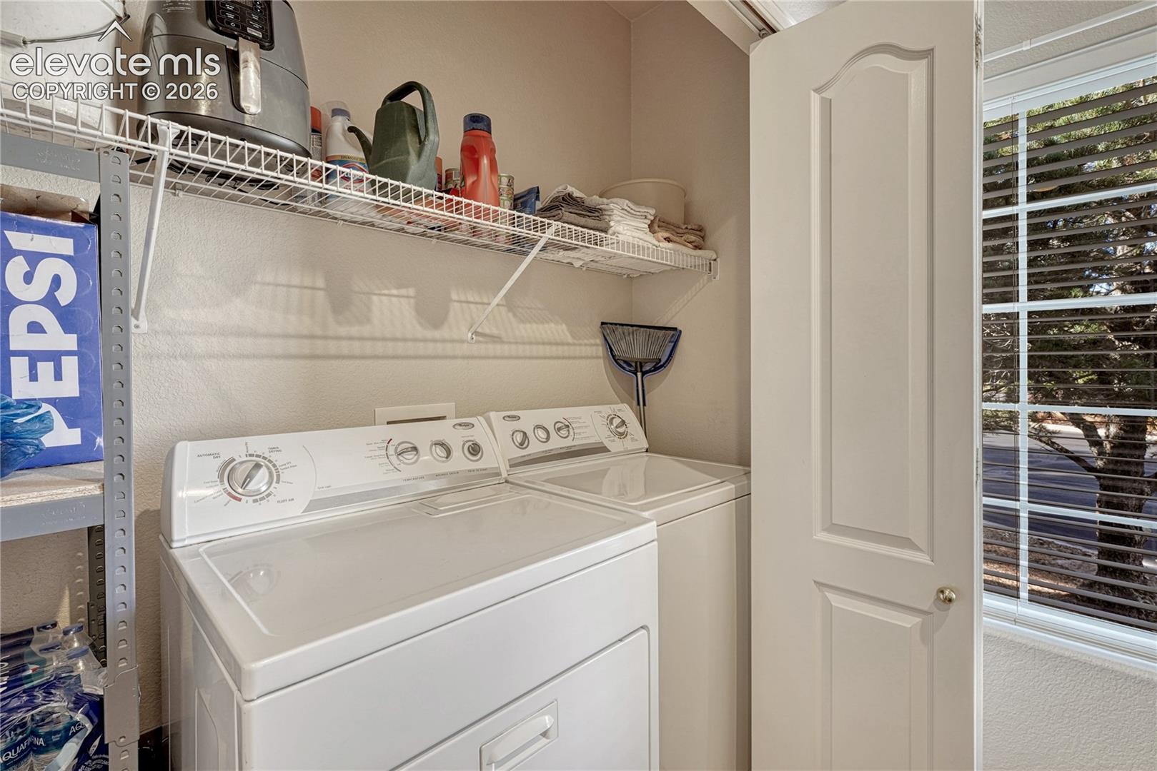 The main-floor utility room comes complete with an included washer and dryer and upper wire rack

