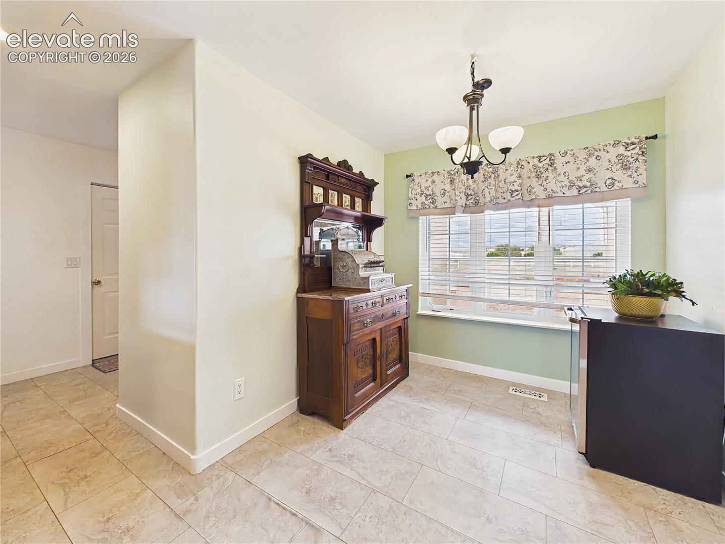 Bright breakfast area is positioned beside large windows, creating a cheerful space to enjoy casual dining while taking in natural light and outdoor views.