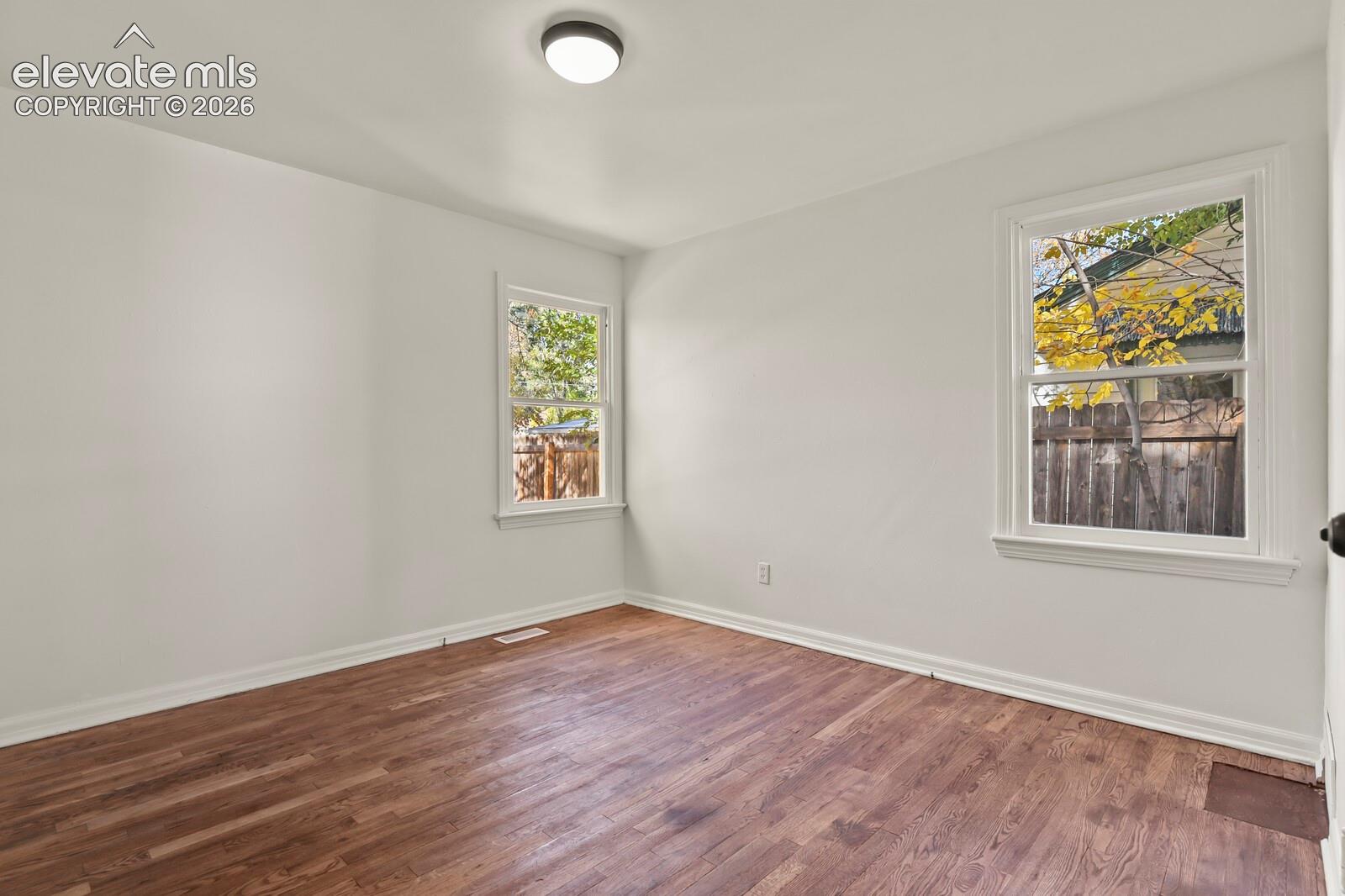 Neutral-toned room featuring wood-finish flooring