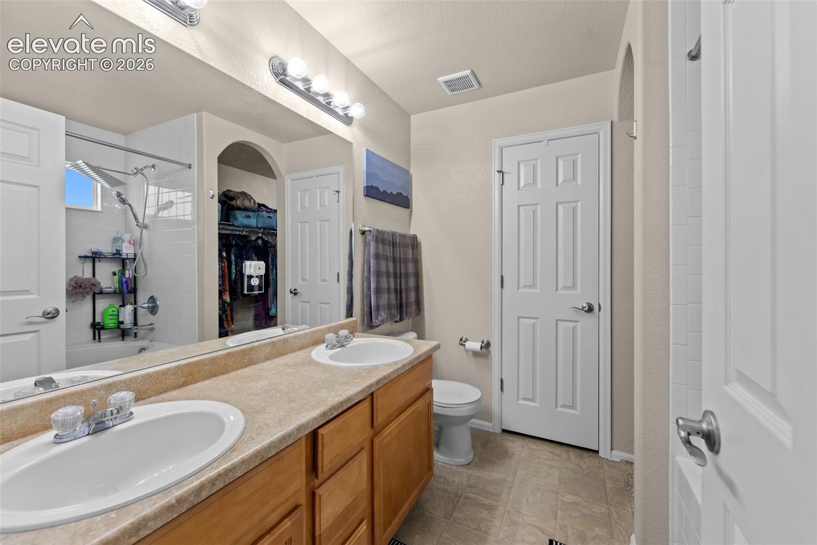 Dual vanity with laminate countertops, two undermount sinks, and chrome faucets