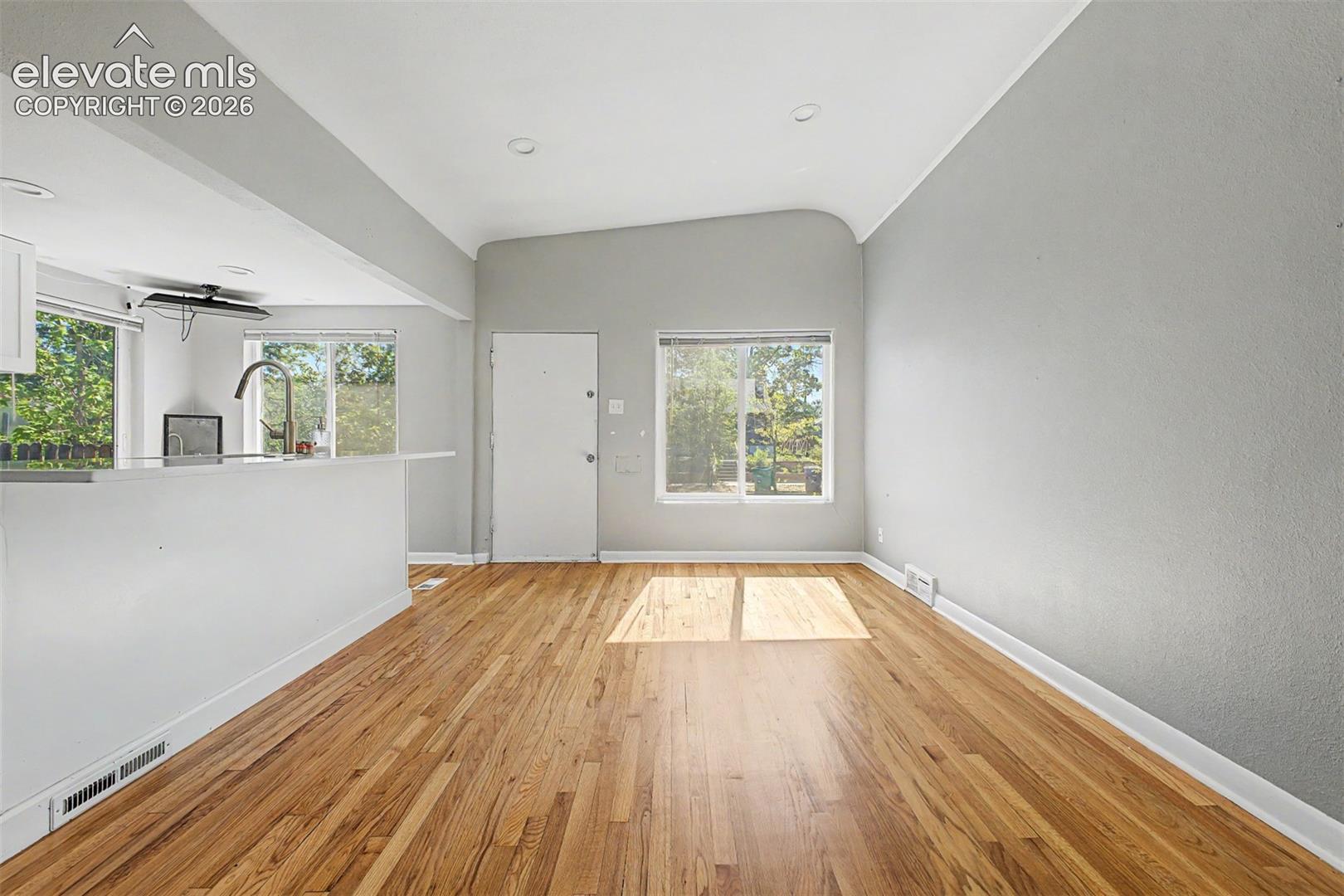 Kitchen featuring white cabinetry, light countertops, and wood-finish flooring