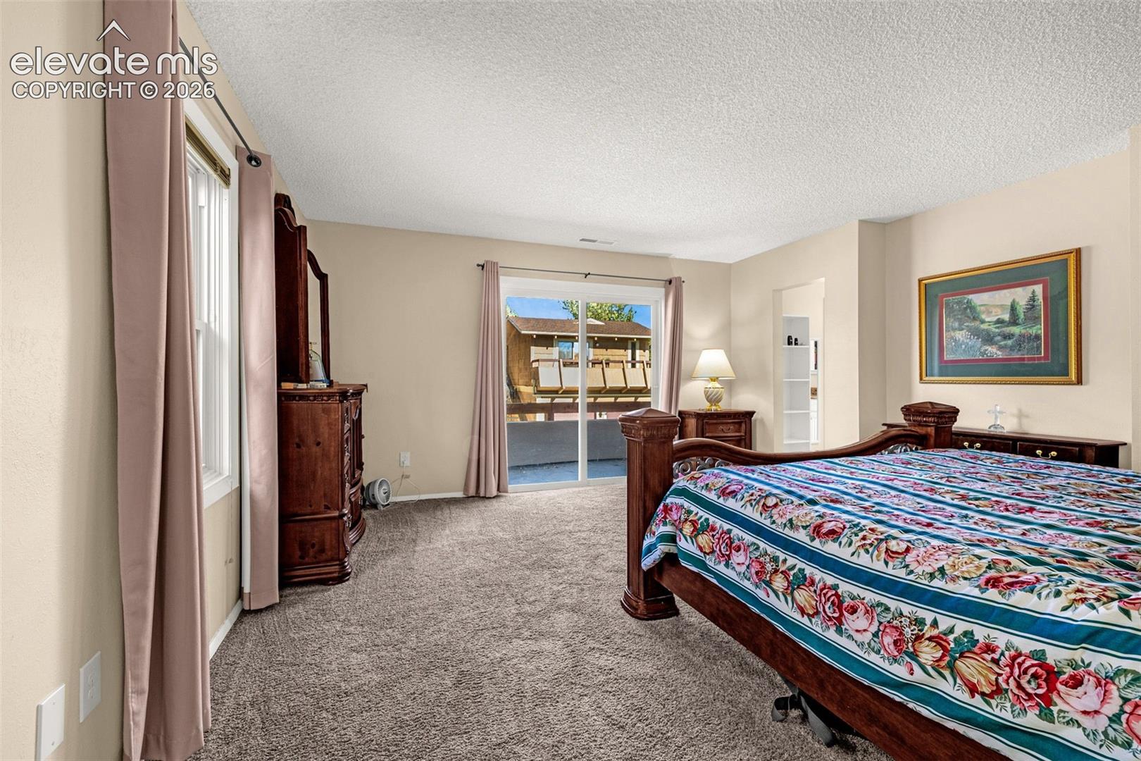 Primary bedroom with sliding glass doors to second balcony