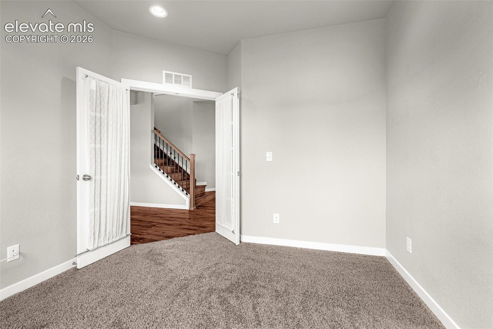 Carpeted room featuring light gray walls, recessed lighting, and white trim