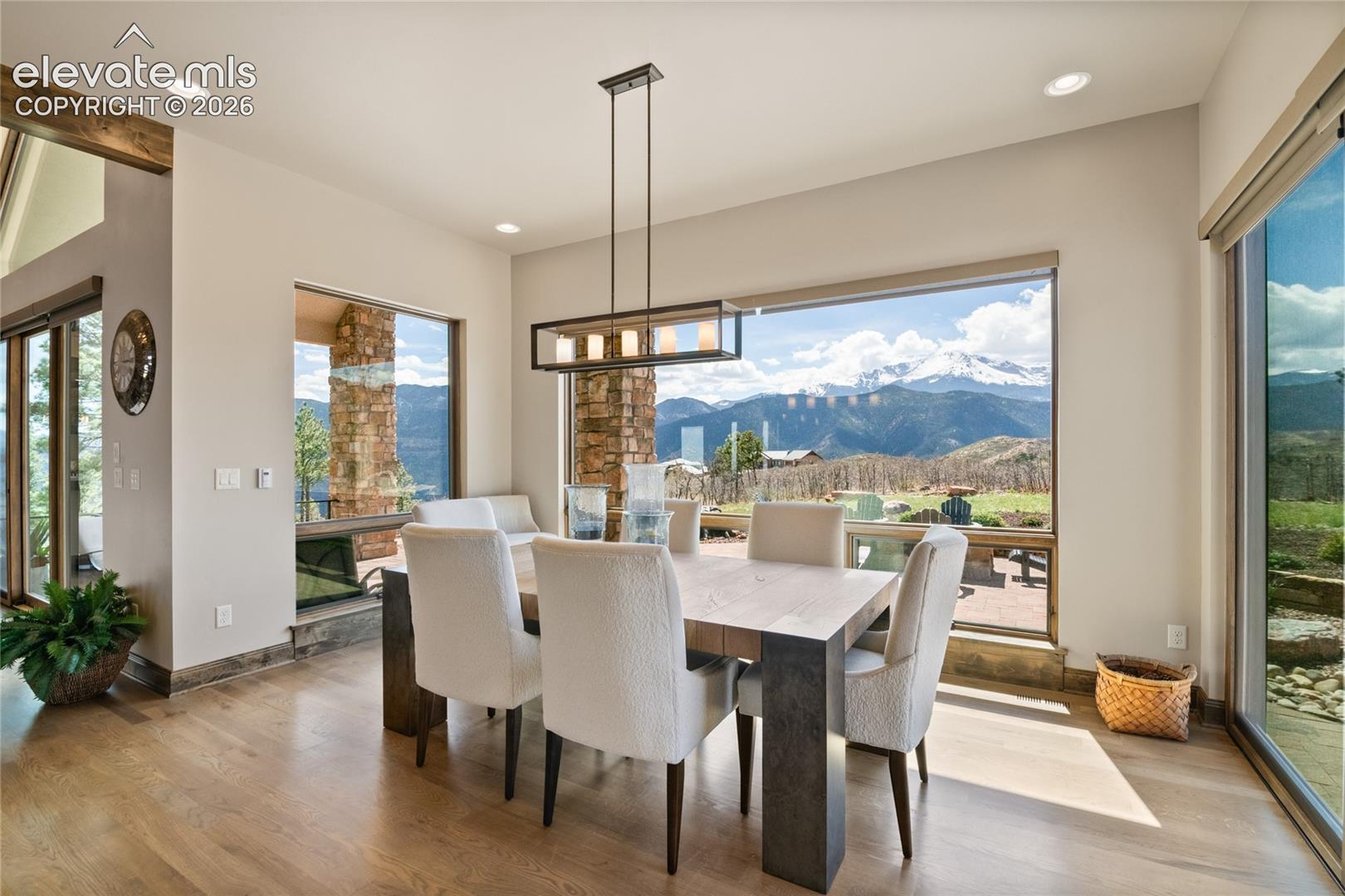 Bright dining space anchored by a 145-inch picture window showcasing Pikes Peak, with walk-out access to the outdoor living area.