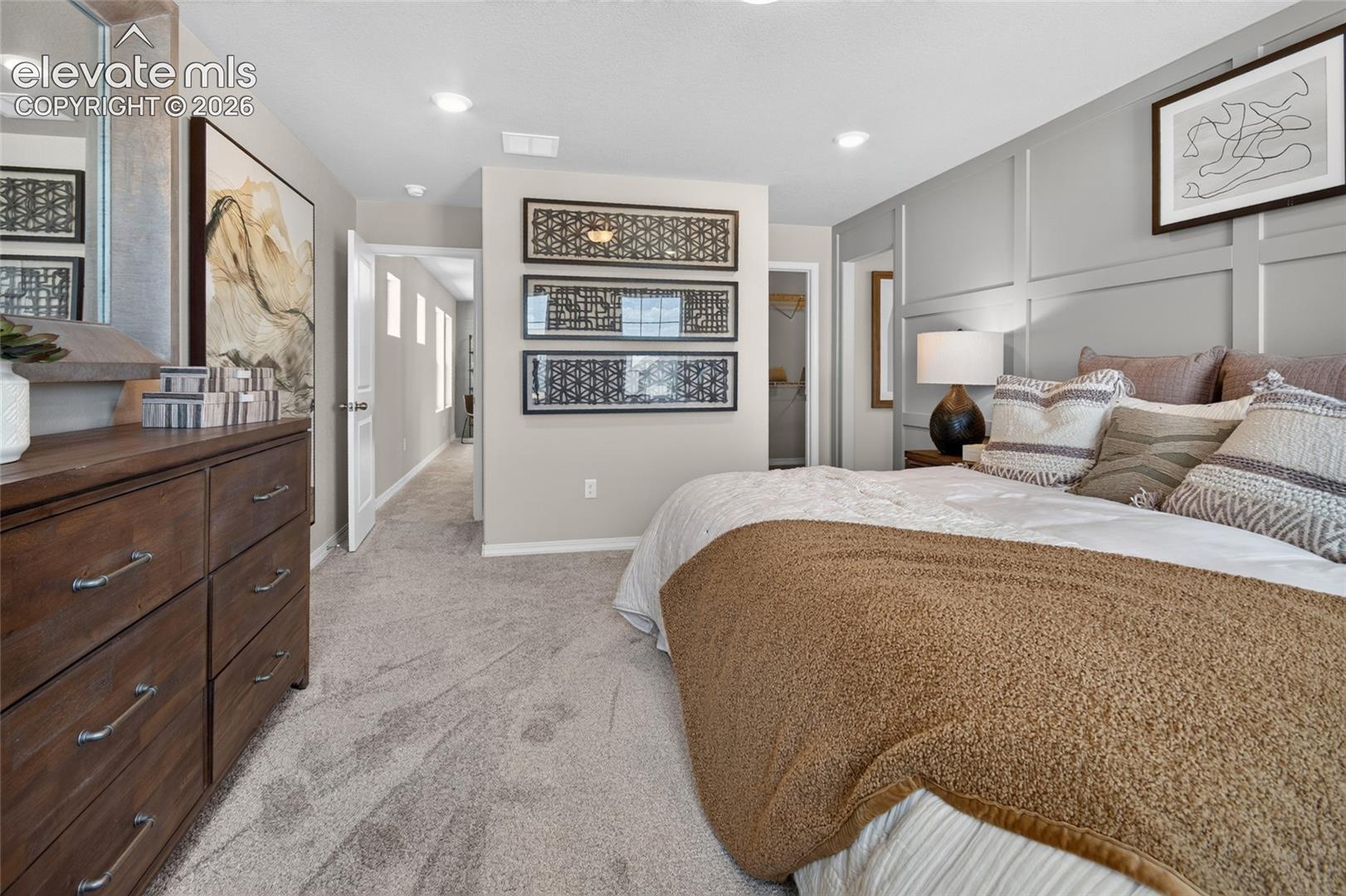 Bedroom featuring wall paneling, carpeting, recessed lighting, and a neutral color palette