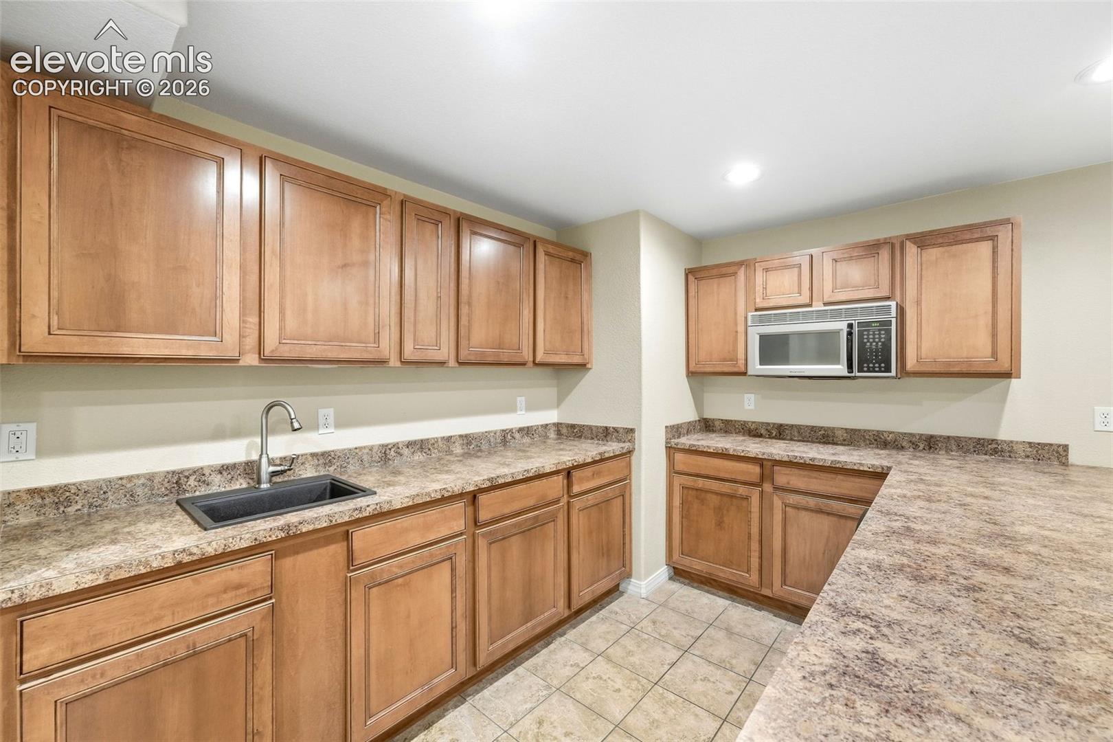Kitchenette with Large Counter Bar and Abundant Cabinetry