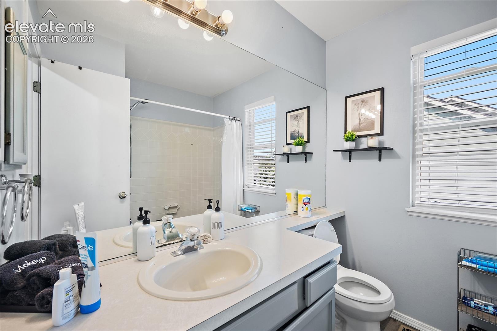 Full-width vanity mirror and countertop with an integrated sink