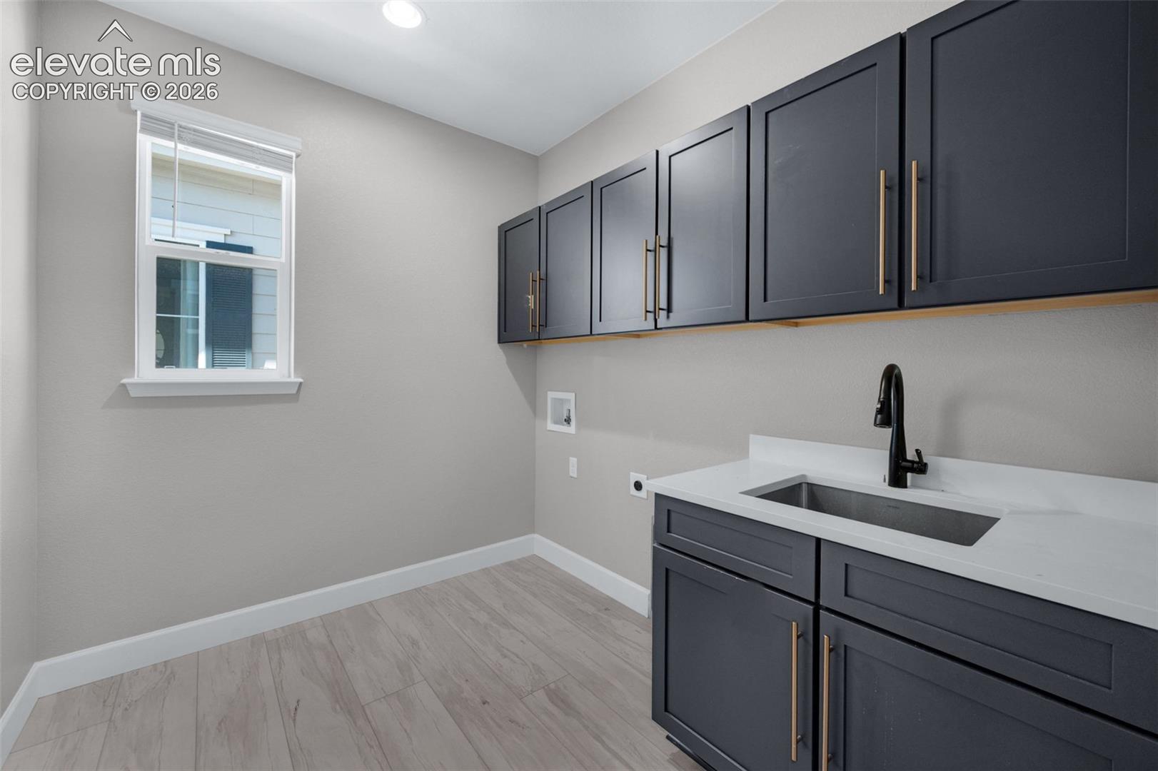 Laundry Room With Cabinets And Quartz Counters