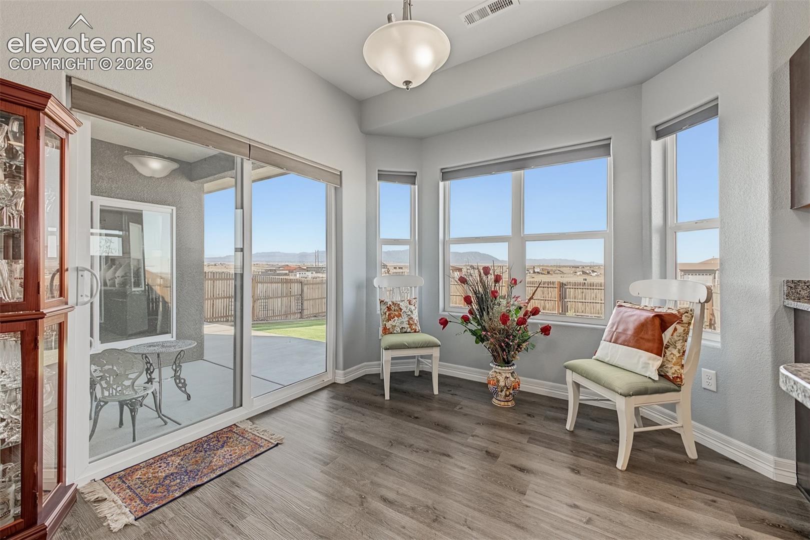 Sun-filled breakfast nook featuring a bay window, sliding glass door access to the patio, and panoramic mountain views.