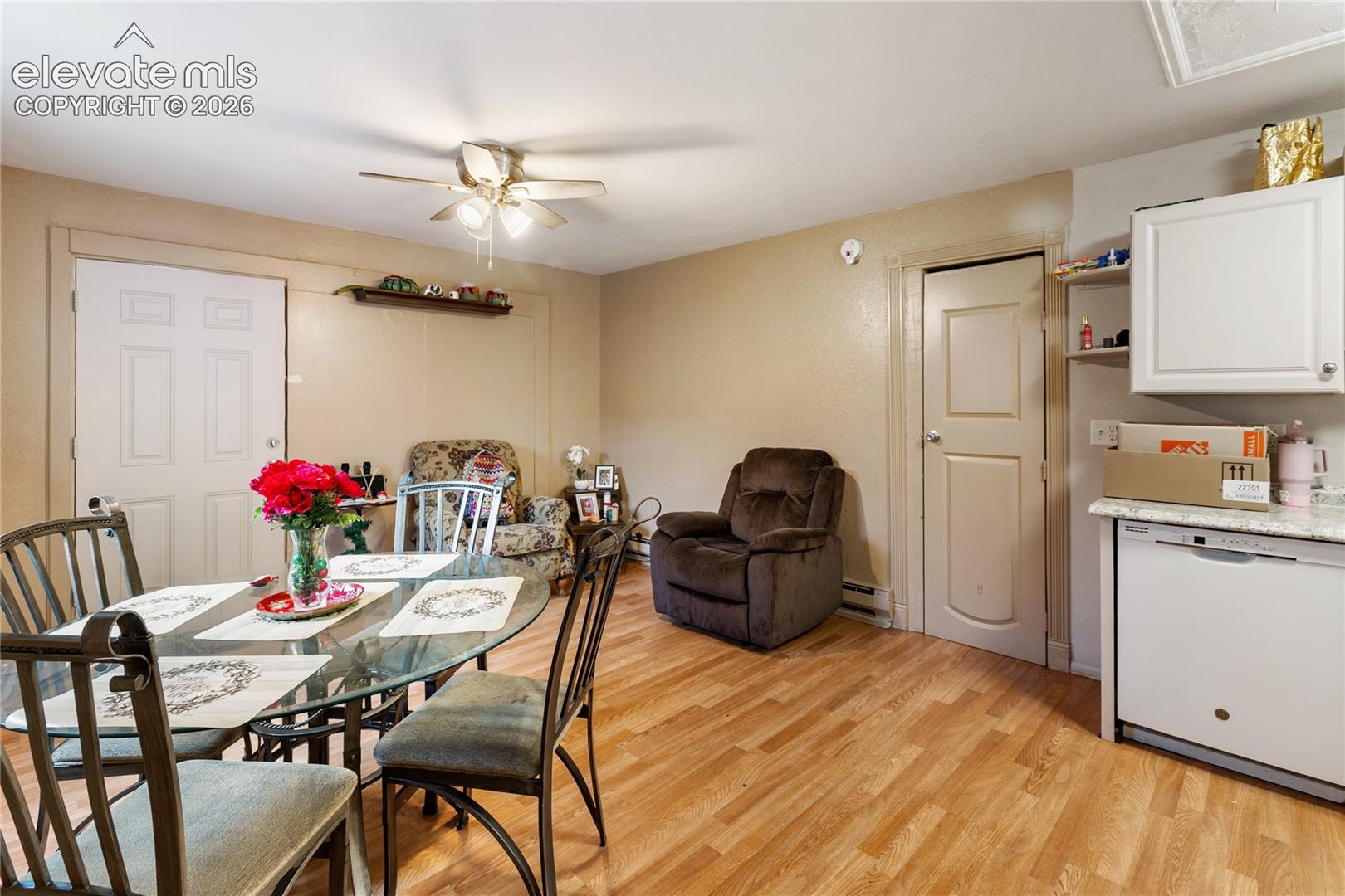 Wood-finish flooring, ceiling fan with integrated lighting, built-in upper cabinetry, and solid-core interior doors