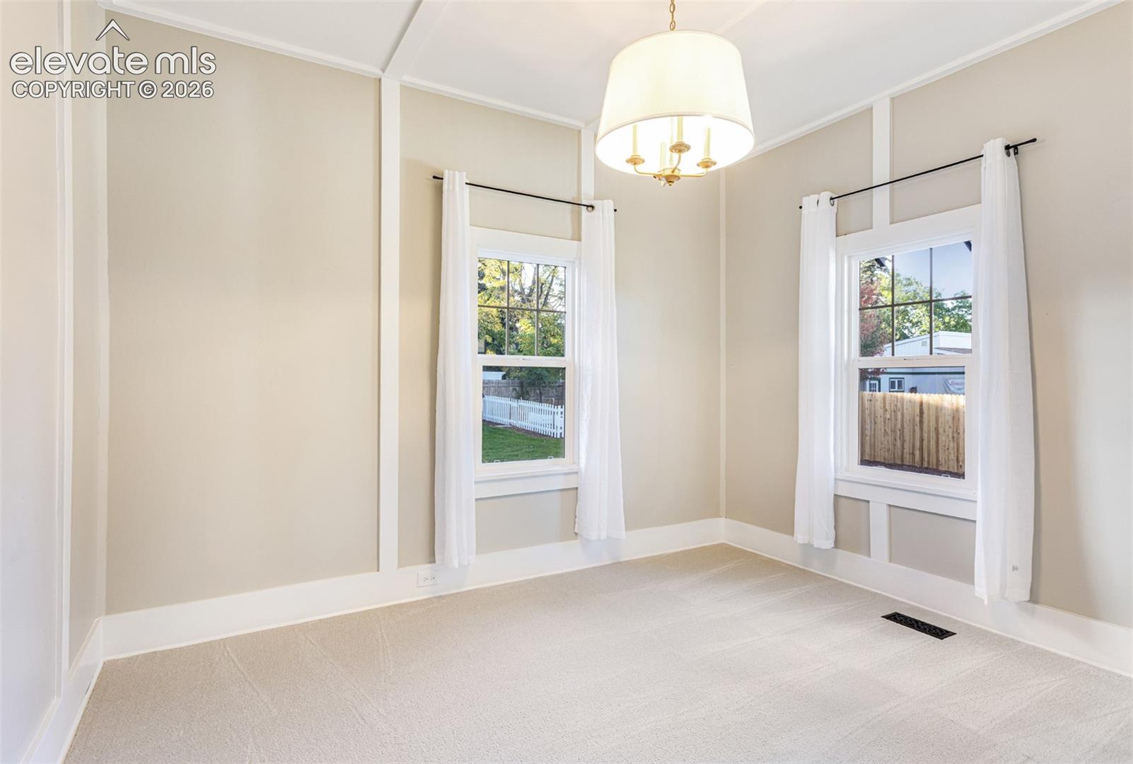 Carpeted room featuring a ceiling-mounted drum pendant light fixture