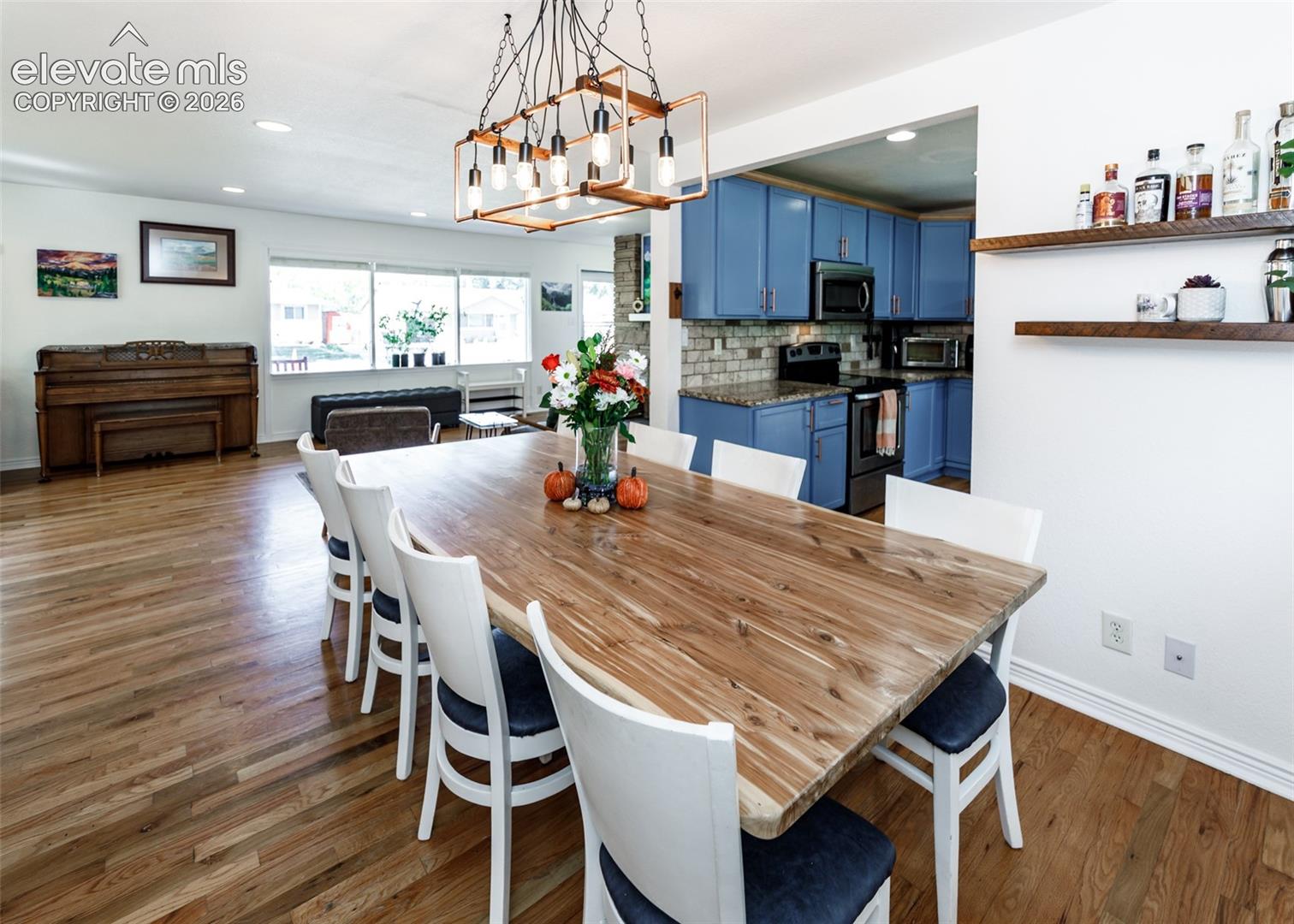 Hardwood flooring throughout, recessed lighting, and a linear chandelier