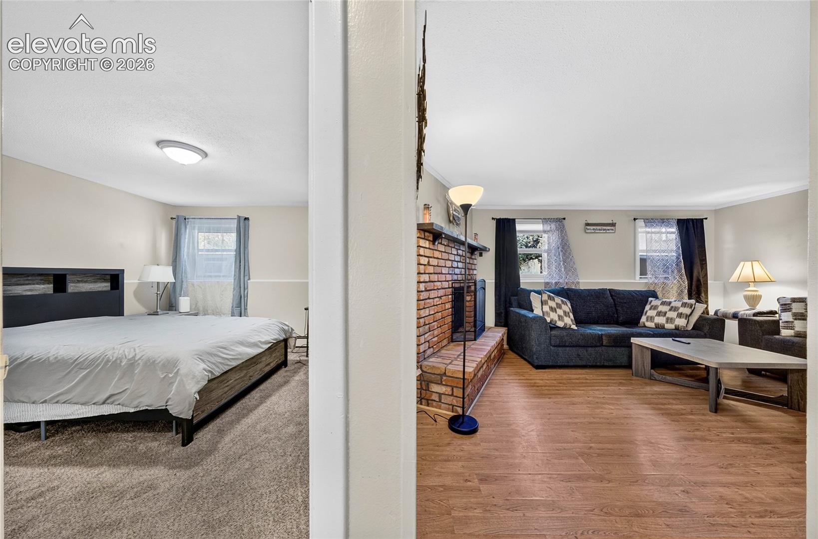 Interior space featuring wood-finish flooring, brick fireplace with a raised masonry hearth, and wall-to-wall carpeting
