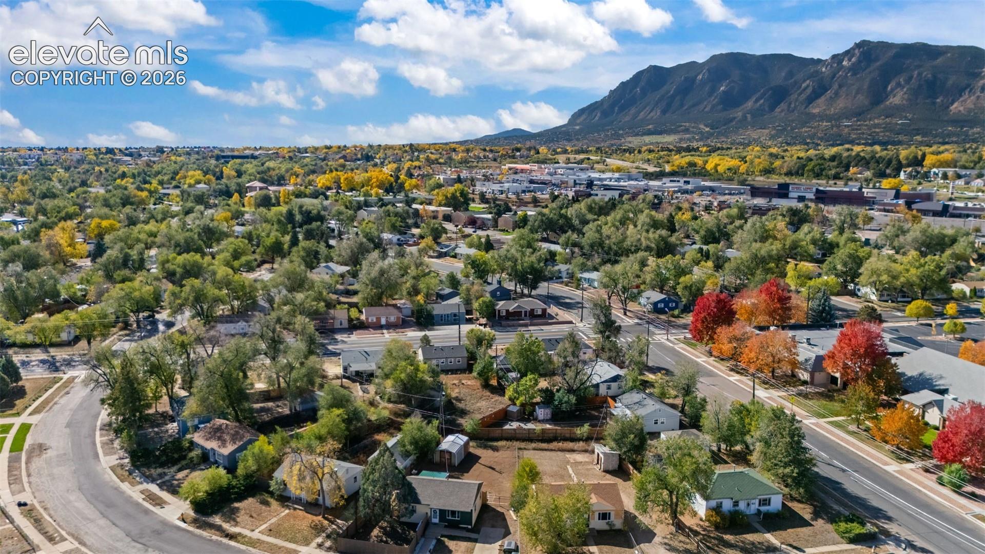 Aerial perspective featuring mature tree-lined streets, established residential lots, and prominent mountain backdrop