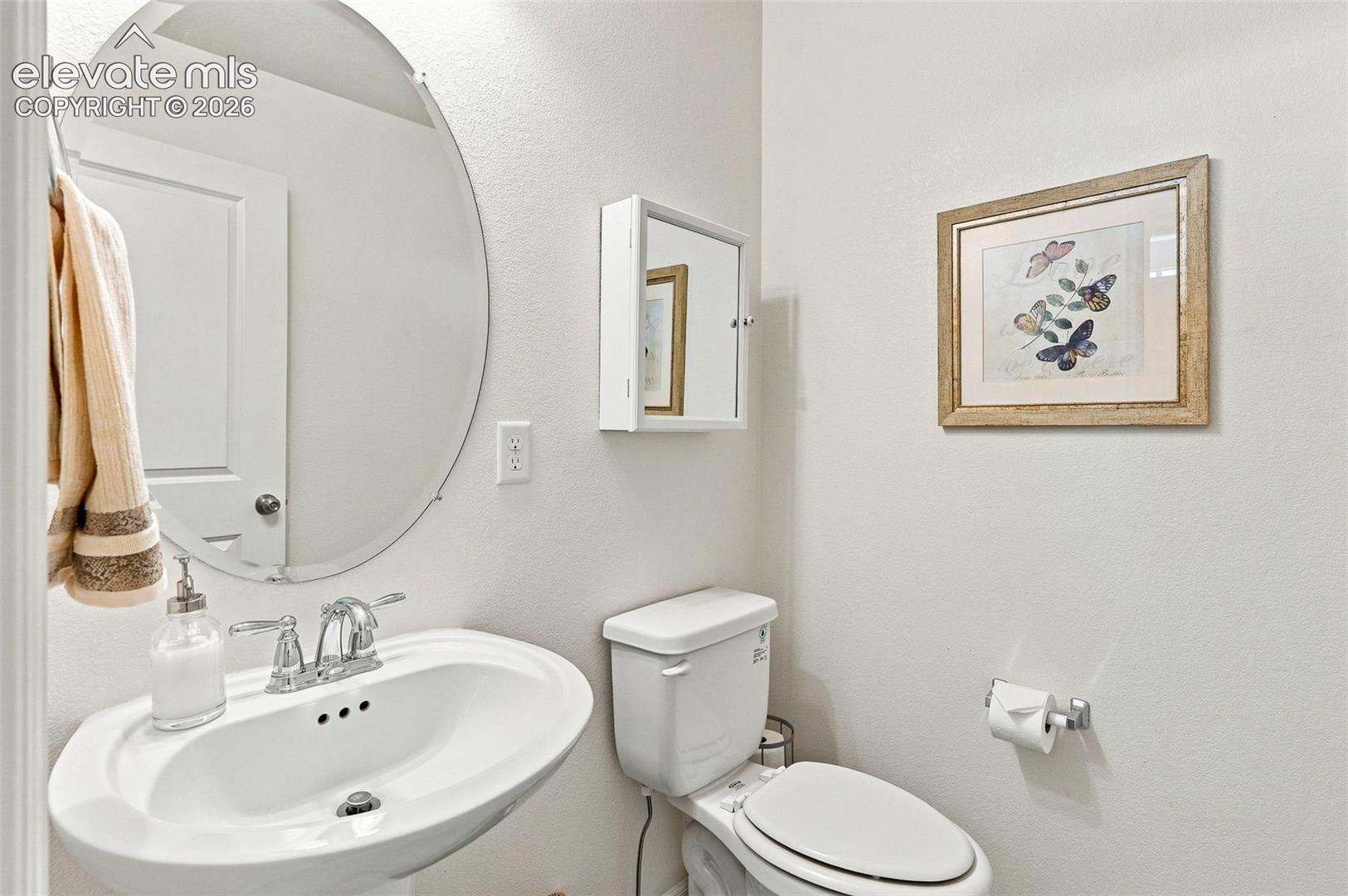 Powder bath with pedestal sink and wood floors