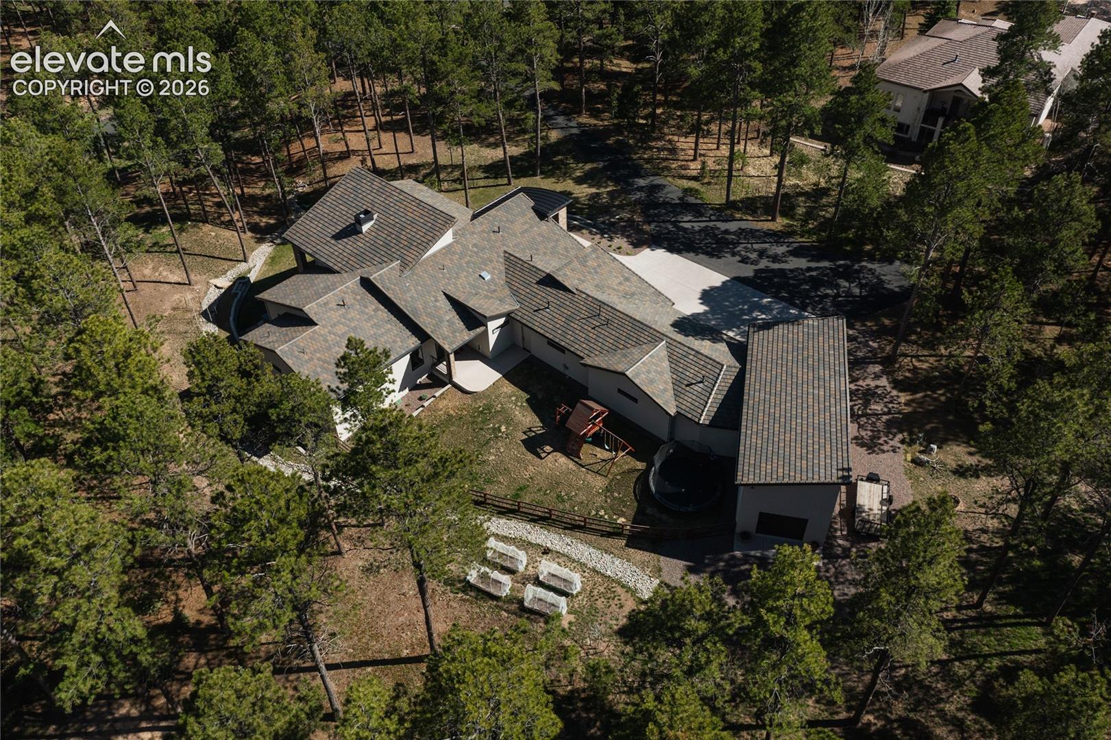 View of subject property with a tree filled landscape