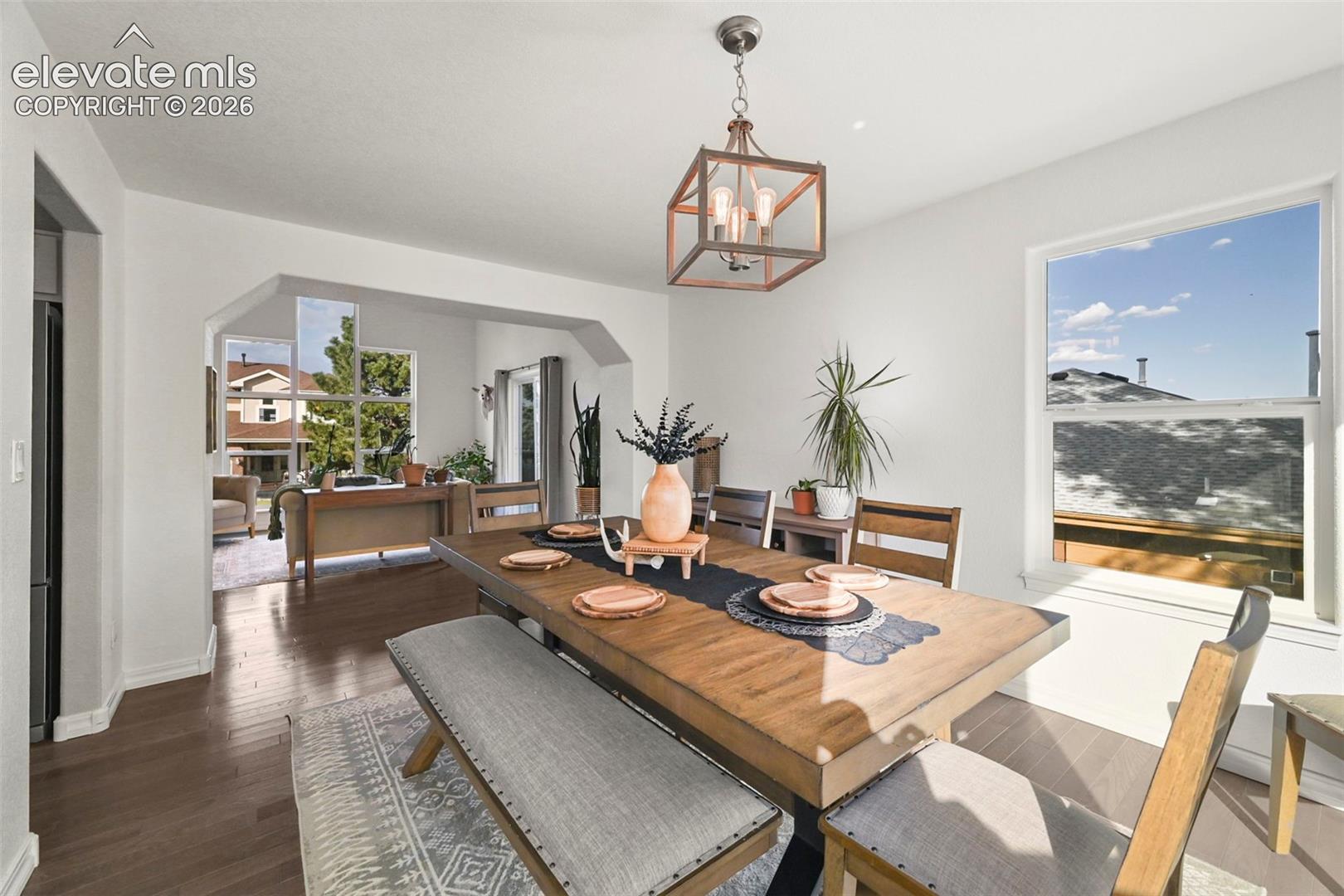 Hardwood-style flooring throughout, an arched entryway, and a hanging lantern light fixture