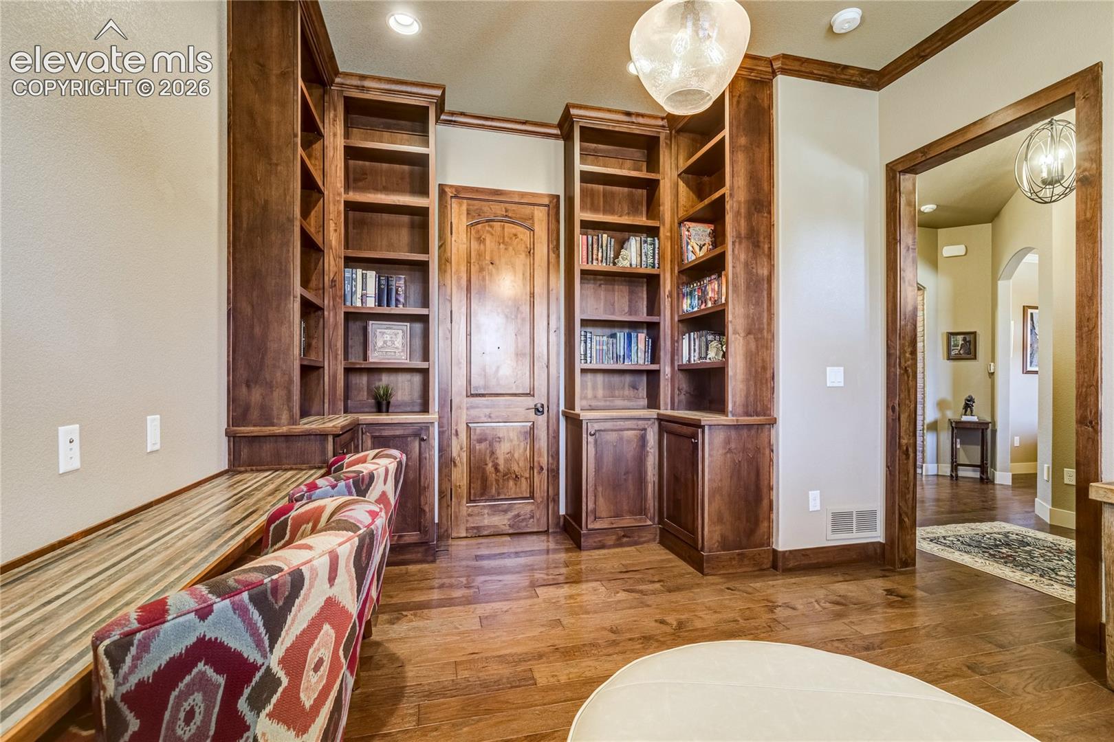 Rich custom bookcases + cabinetry provide a striking focal point in the dedicated study, combining handsome craftsmanship with functional storage. Barn doors + a walk-in closet further enhance this versatile main-level space.