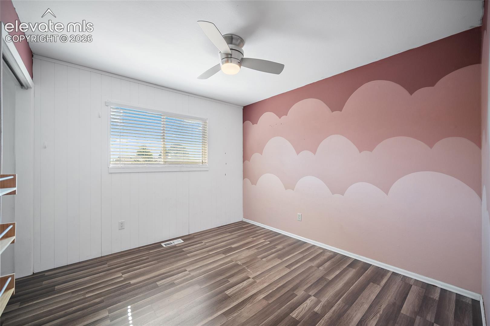 Bedrom with ceiling fan and updated flooring.