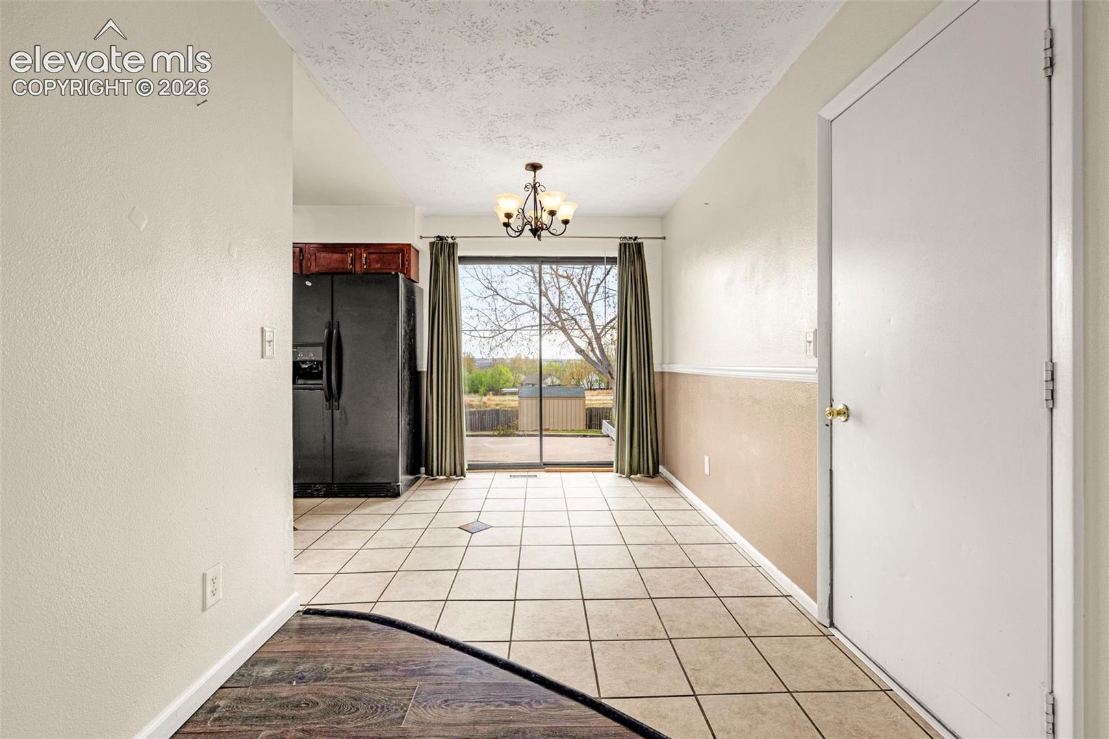 Dining area with walkout to back patio, tile floor and door to garage
